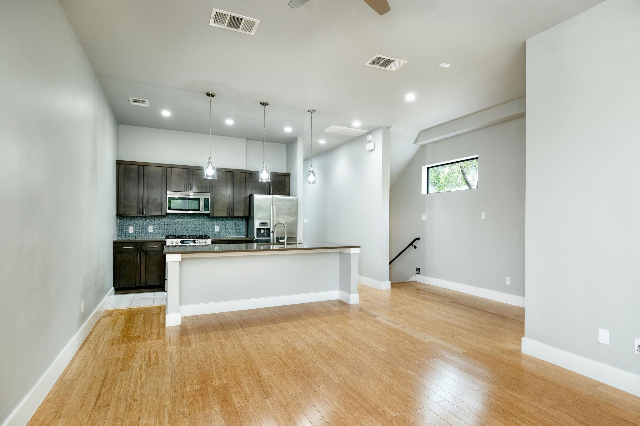 A contemporary open-concept space features hardwo