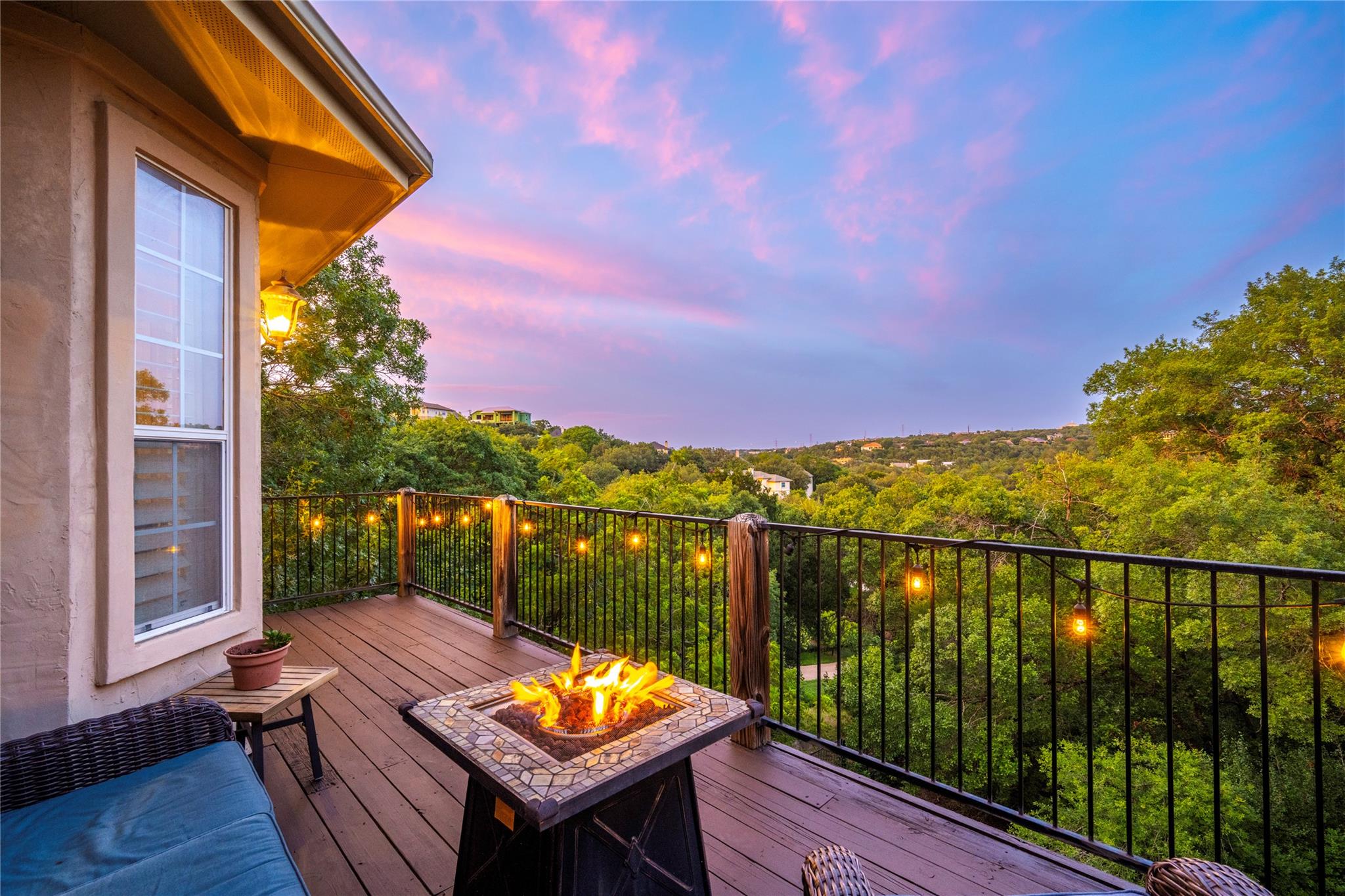 An elevated wood deck overlooks sweeping green tr