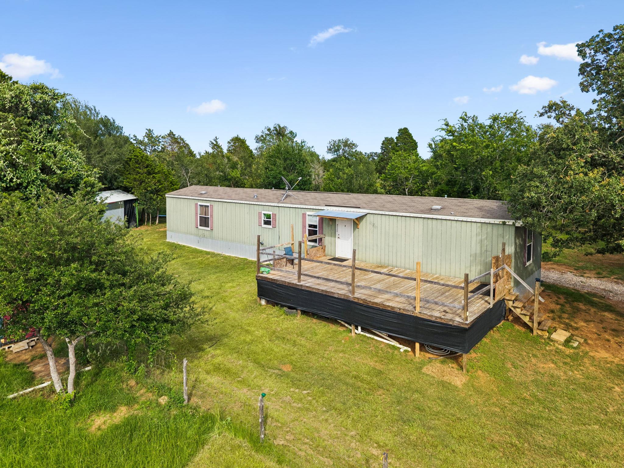 A spacious wood deck extends from this verdant, n