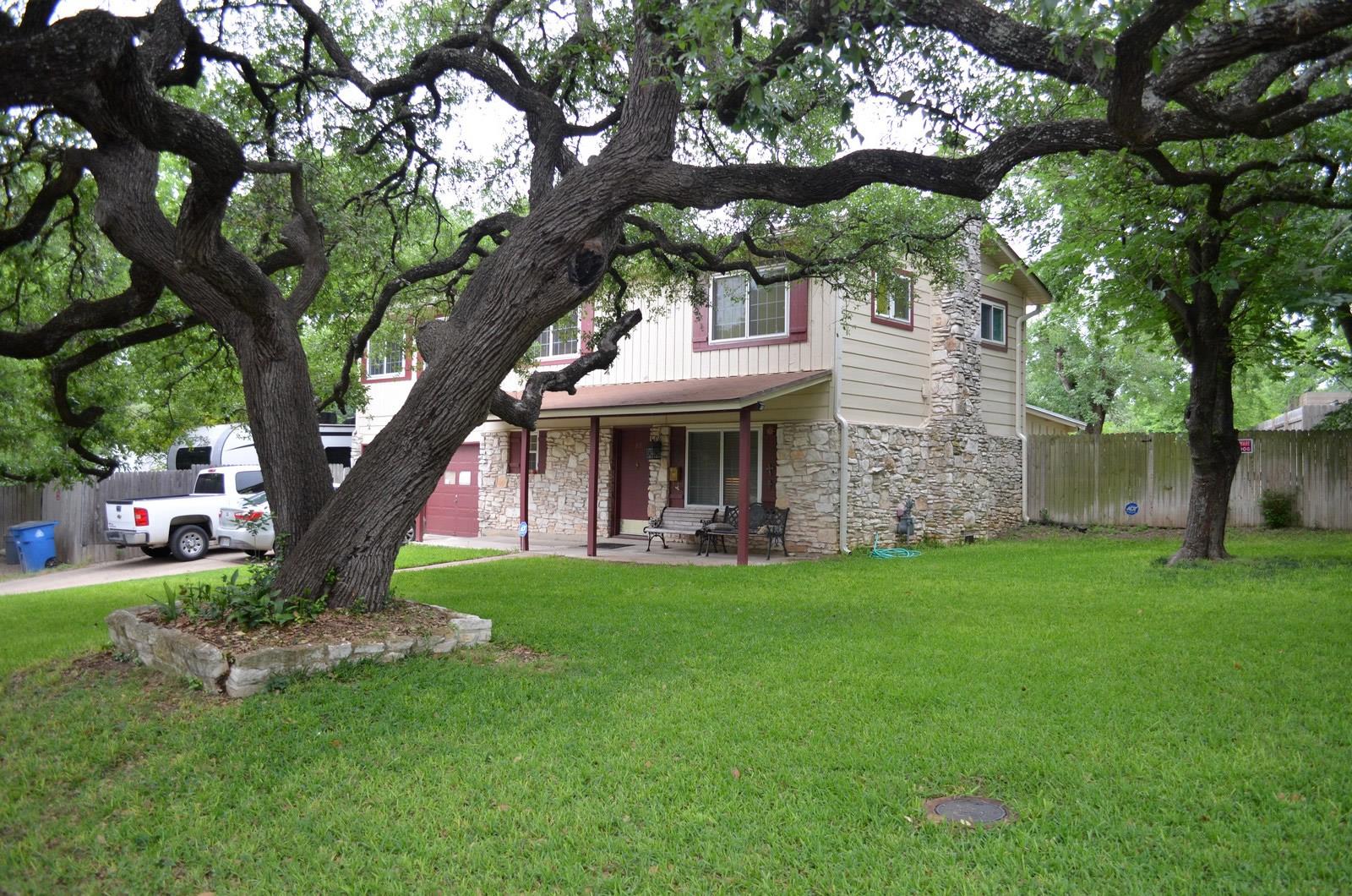 Mature trees shade this home's stone and siding e