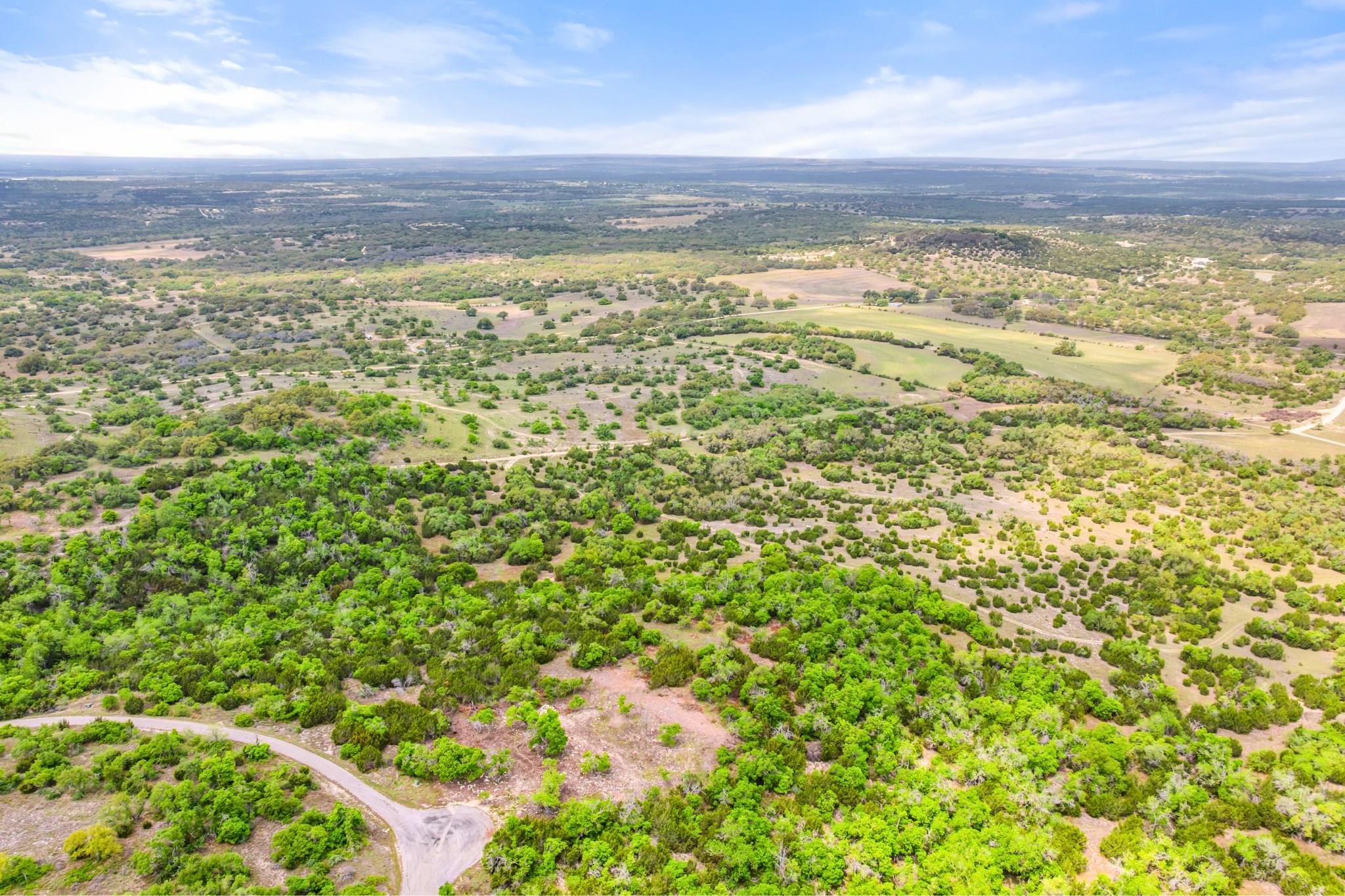 Vast green acreage extends under a serene sky, of