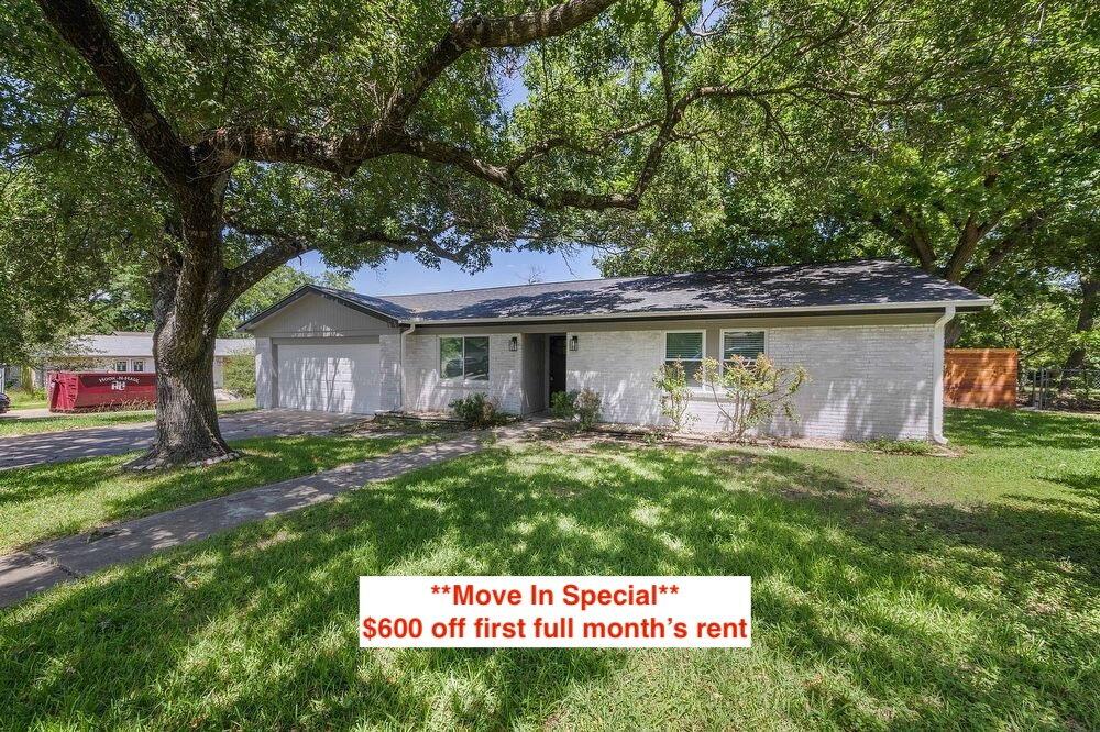 Mature shade trees frame this classic single-stor