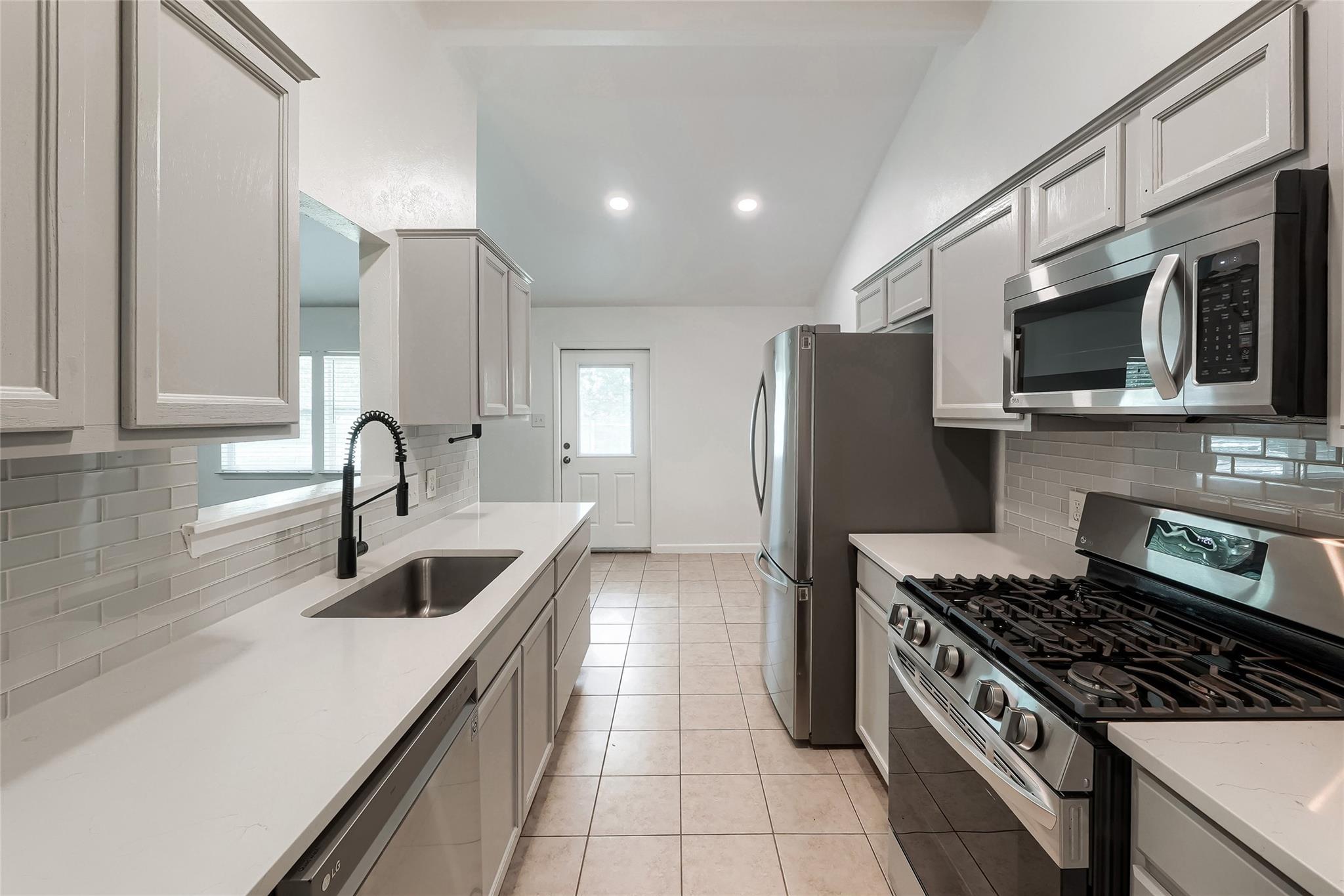 Streamlined kitchen features a gas range and slee