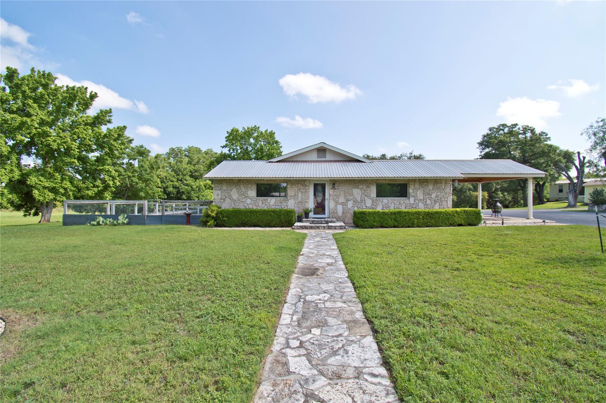A stone walkway leads to a charming stone house w