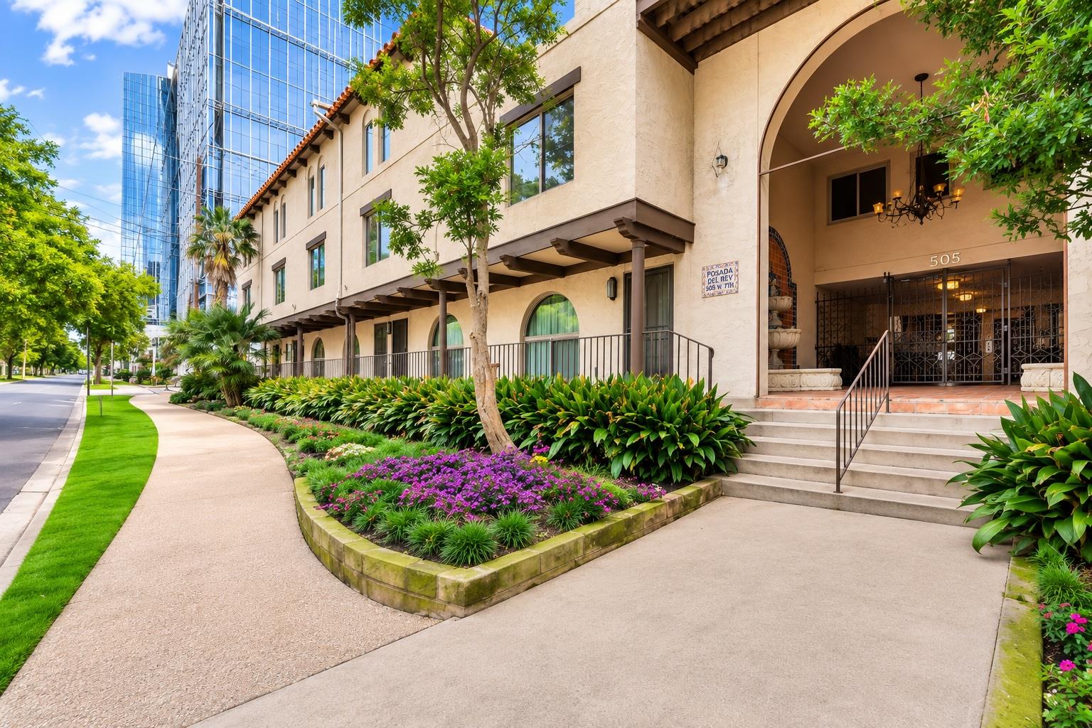 Lush landscaping and arched entries adorn this cl