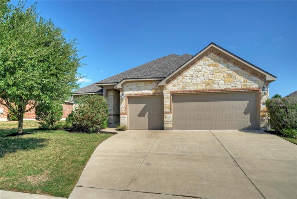A well-maintained concrete driveway leads to a tw