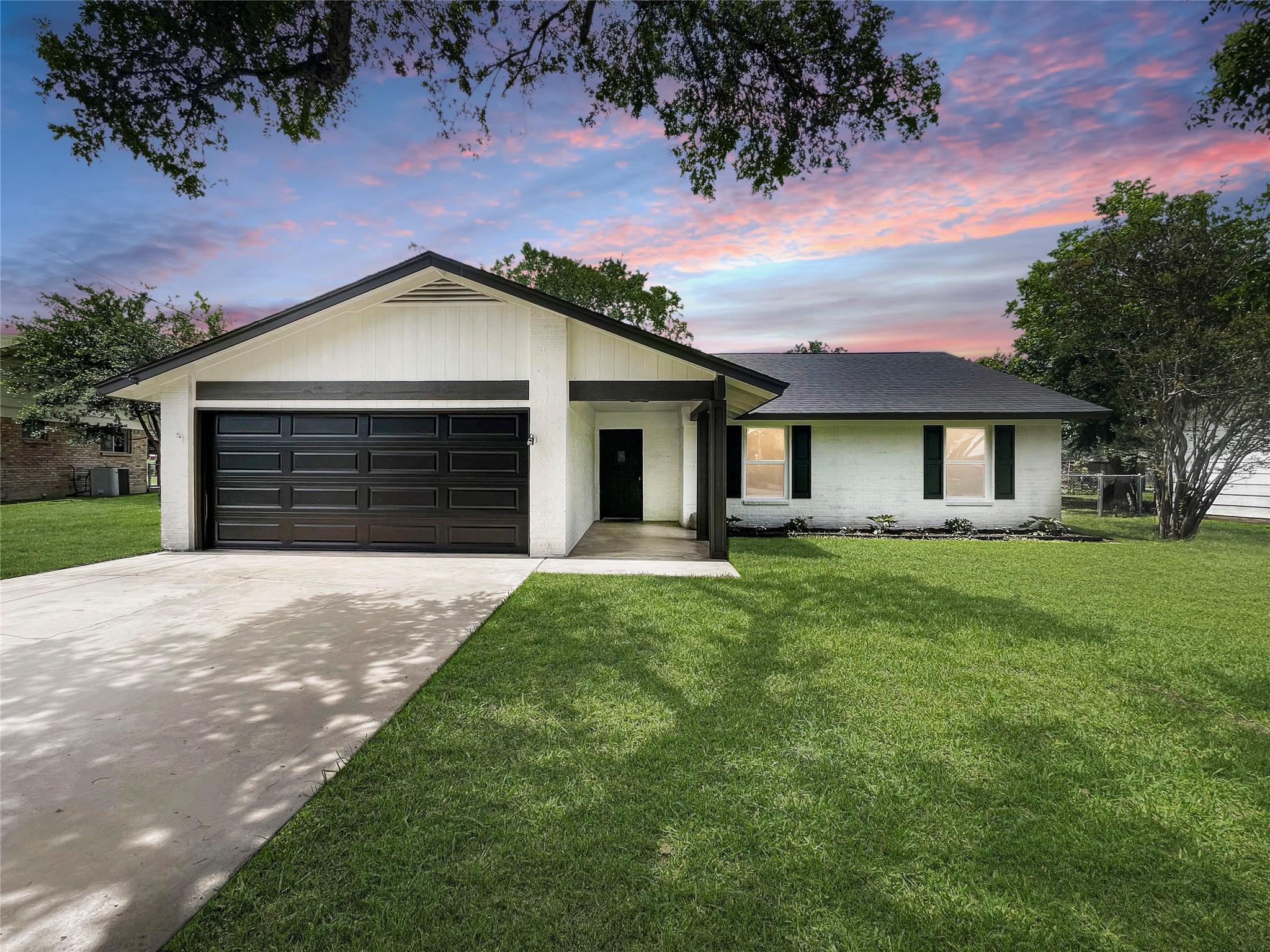 A well-maintained lawn and paved driveway welcome