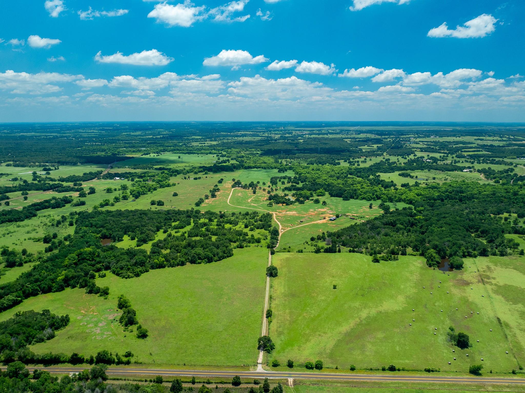 Vast green pastures and wooded expanses define th