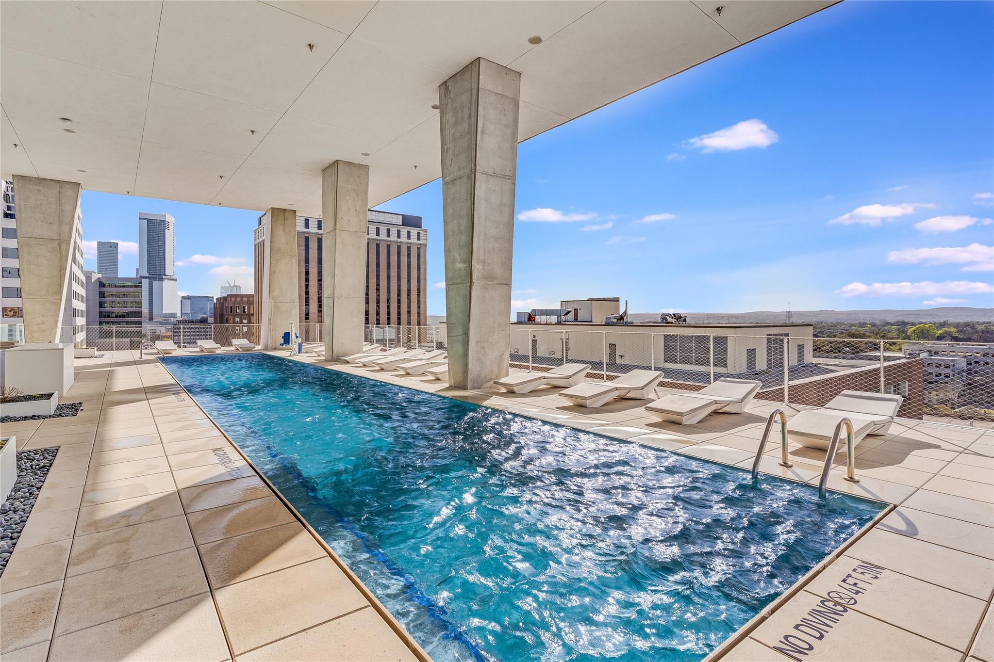 City skyline views from a sleek rooftop pool, per