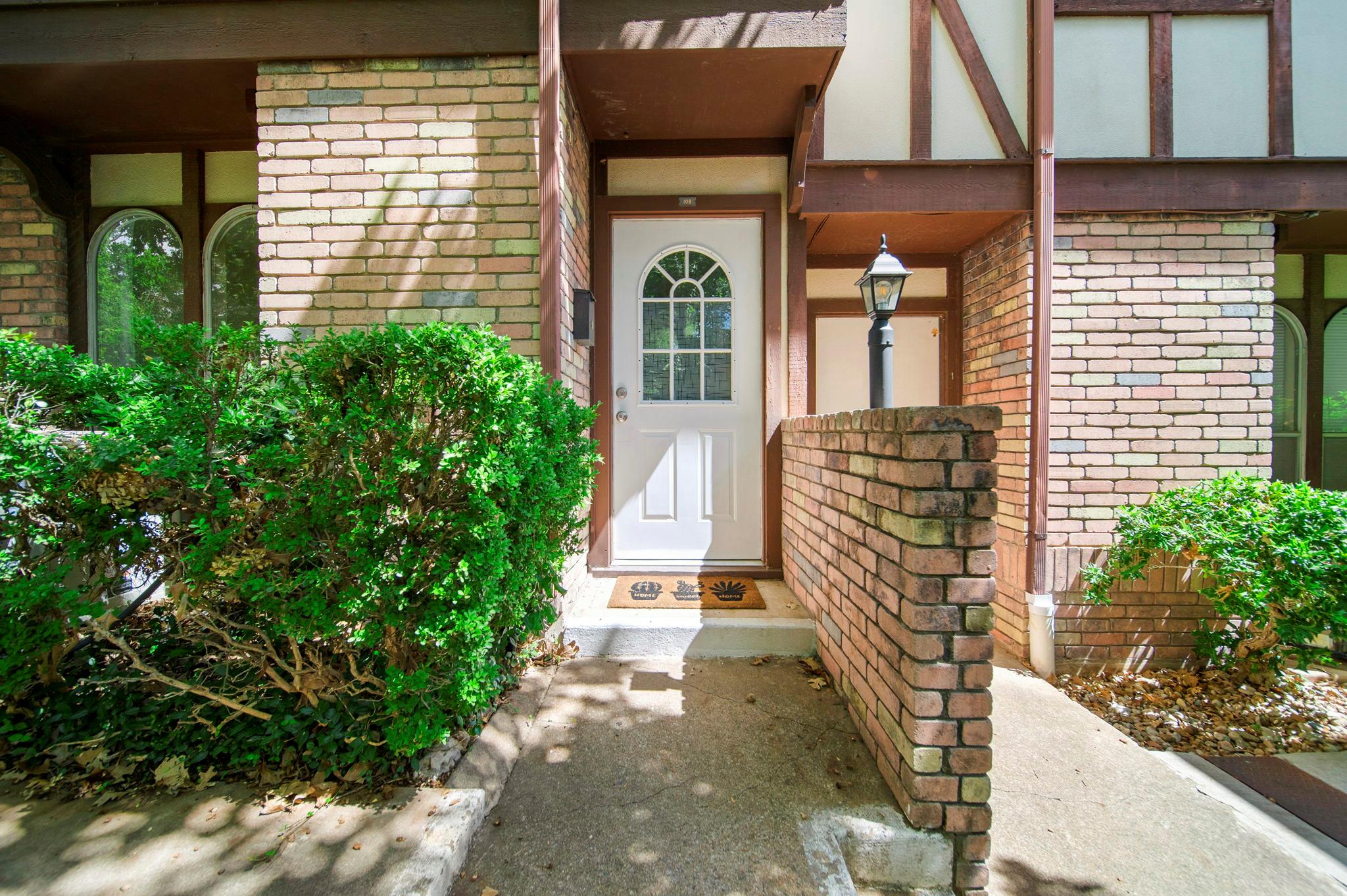 A welcoming white front door beckons from this ch