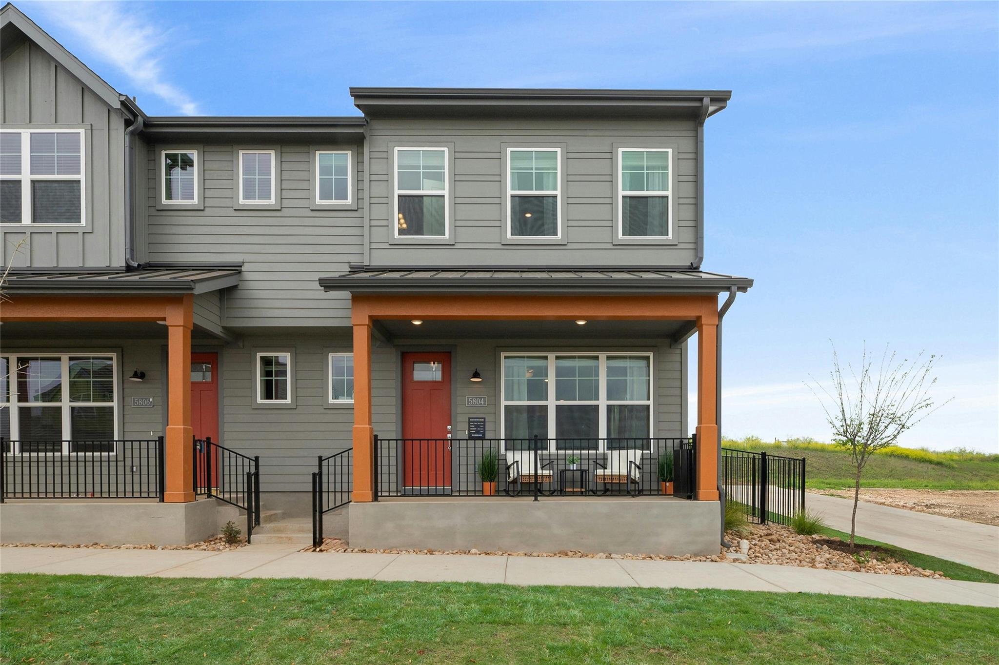 A welcoming front porch with a red entry door cre