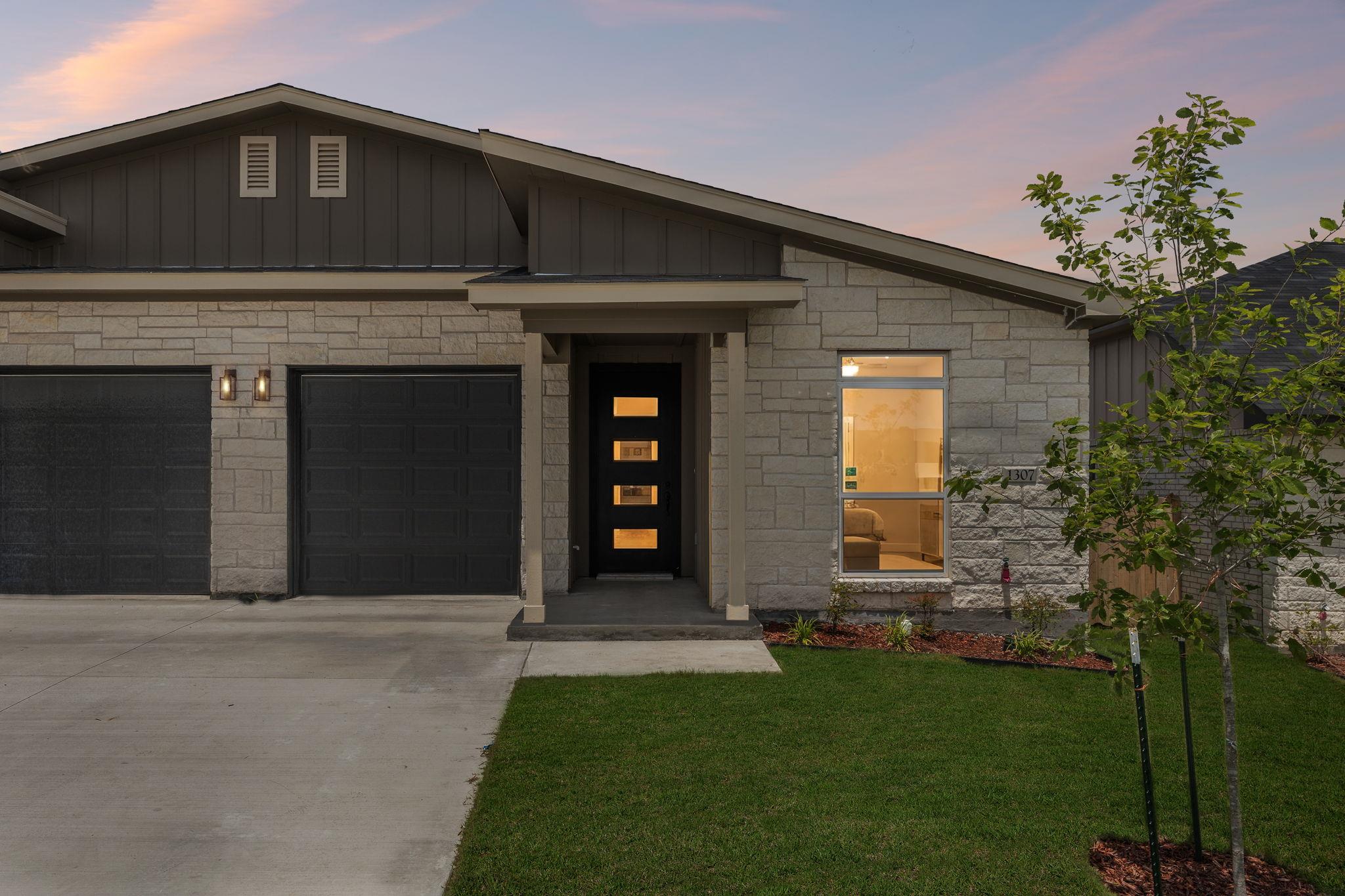 A contemporary façade boasts a stone and siding c