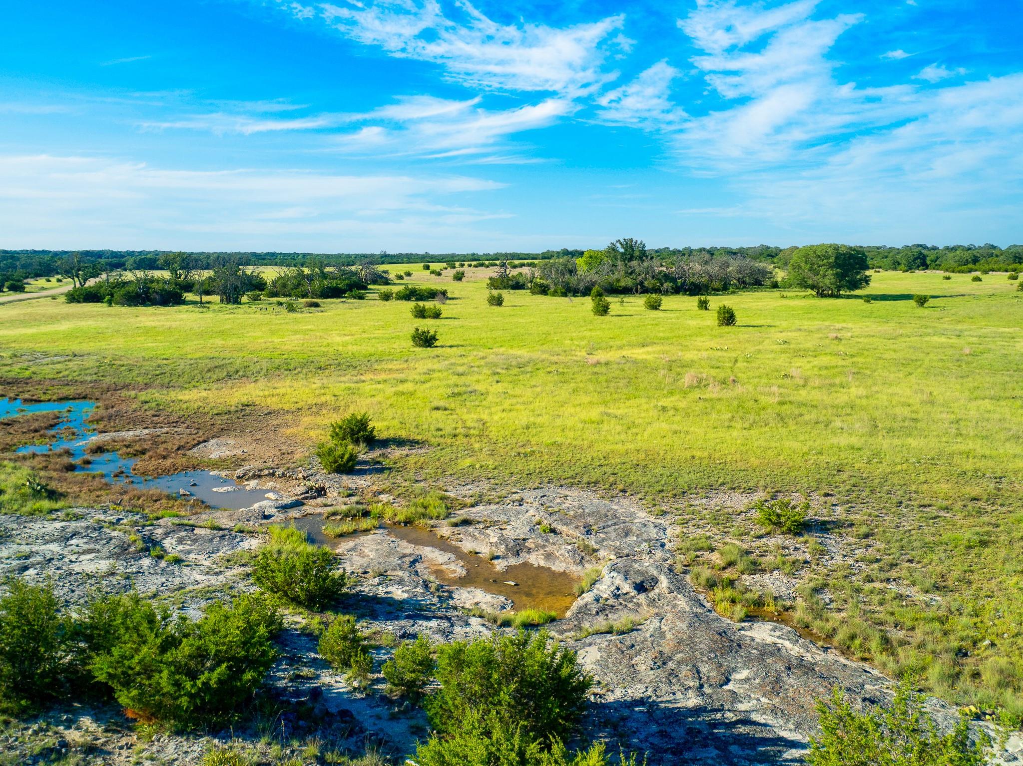 Vast natural terrain unfolds under a wide-open sk