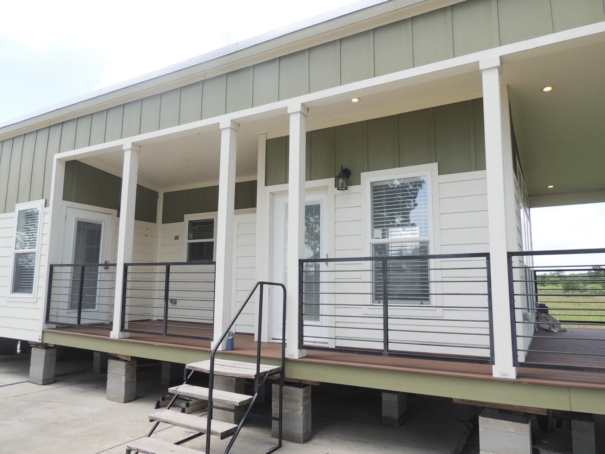 A welcoming front porch with sleek railings exten