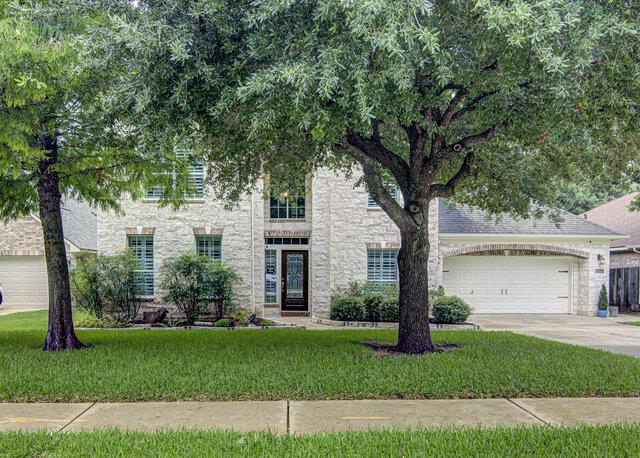 A classic brick and stone facade welcomes with ma