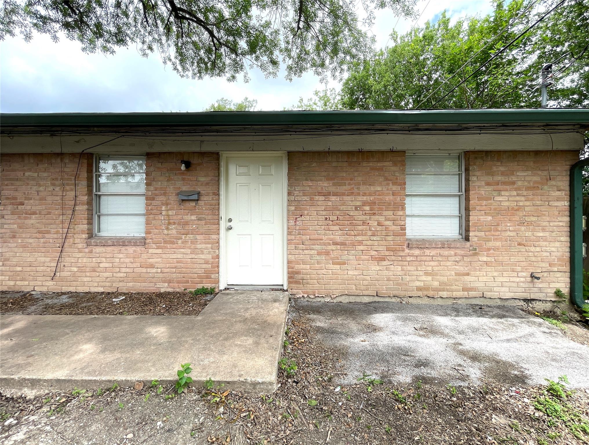 Brick facade with a clean entry beckons to a cozy