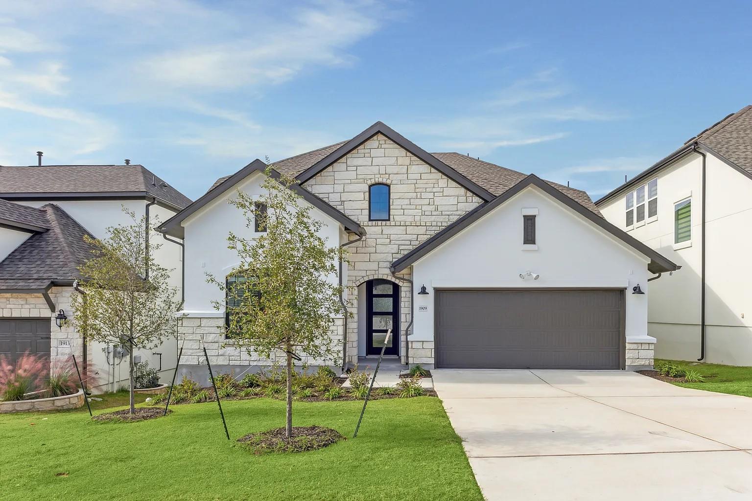 A striking facade with white stucco and stone acc