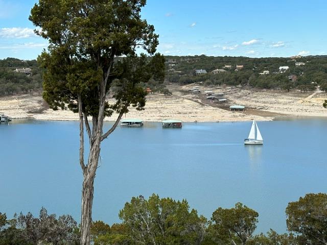 A tranquil lake view features a sailboat gliding 