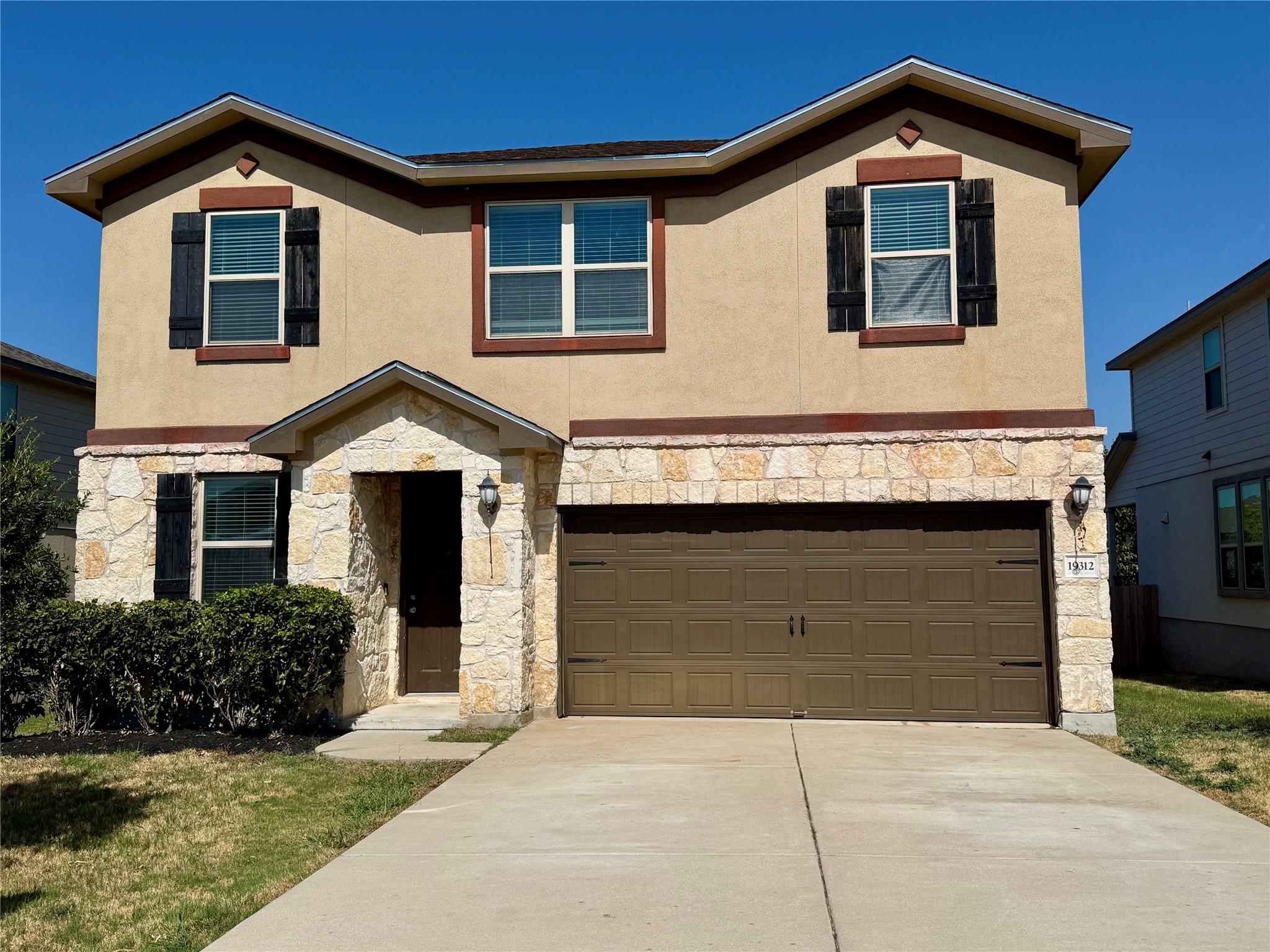 Textured stucco and natural stone accents define 