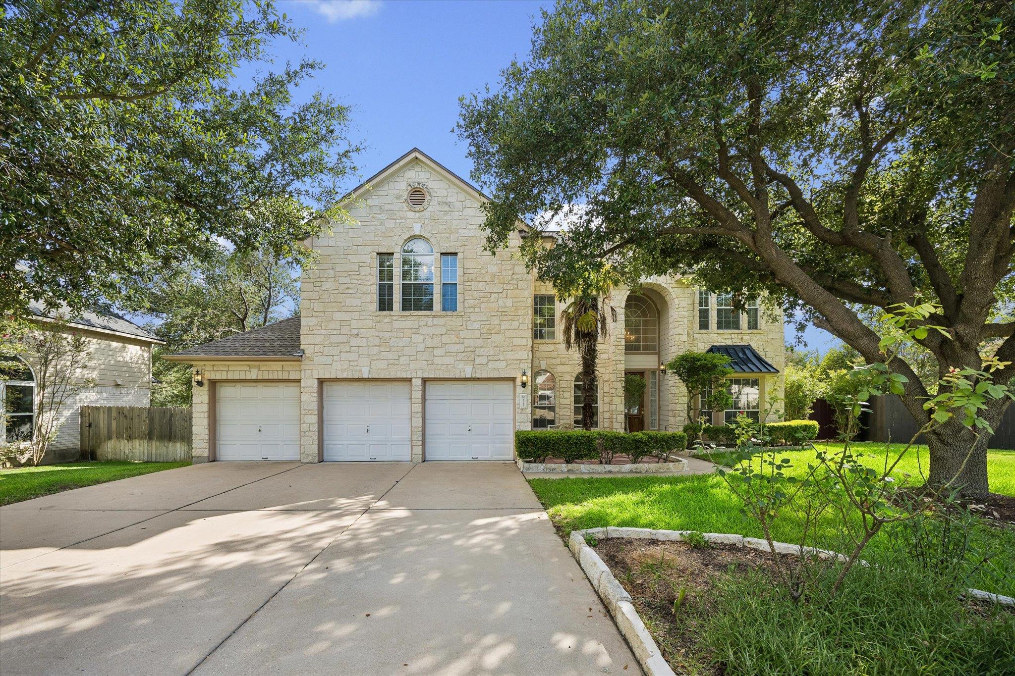 A grand, stone-clad residence framed by mature tr