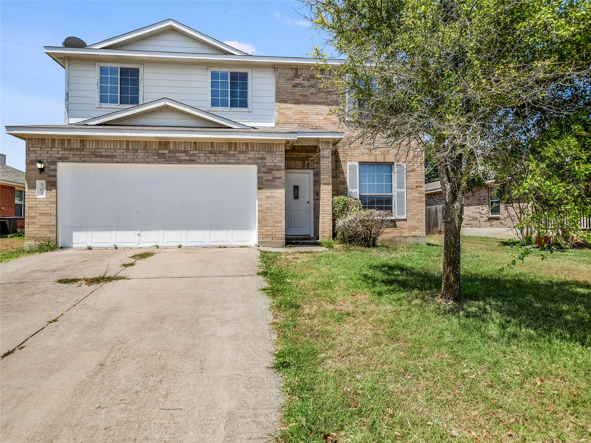 A well-kept front yard and brick facade enhance t