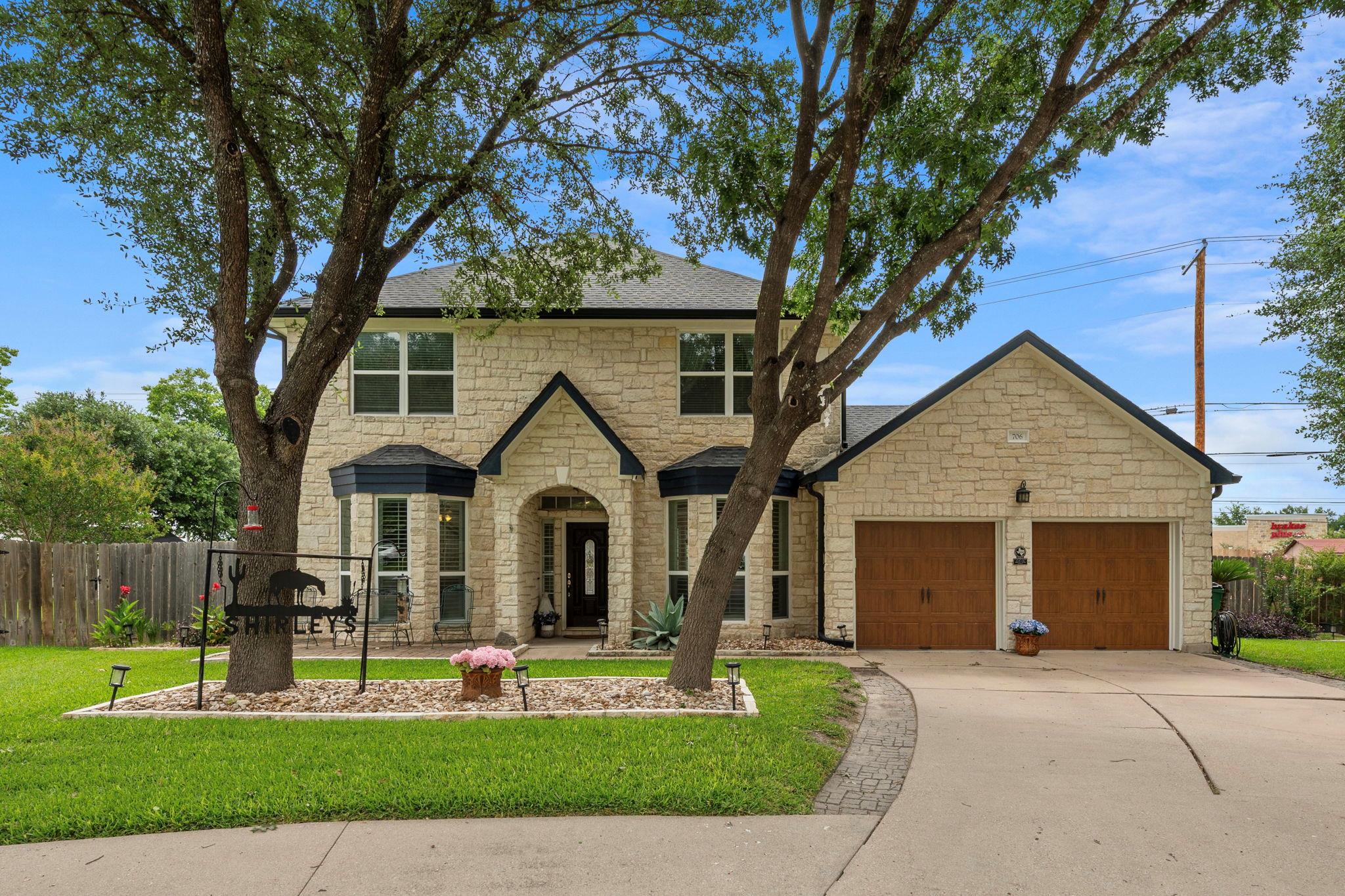 A classic stone facade with dark trim and rich wo