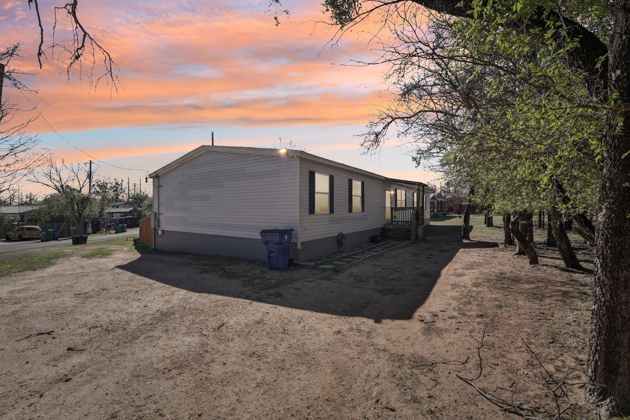 A manufactured residence nestled among mature tre