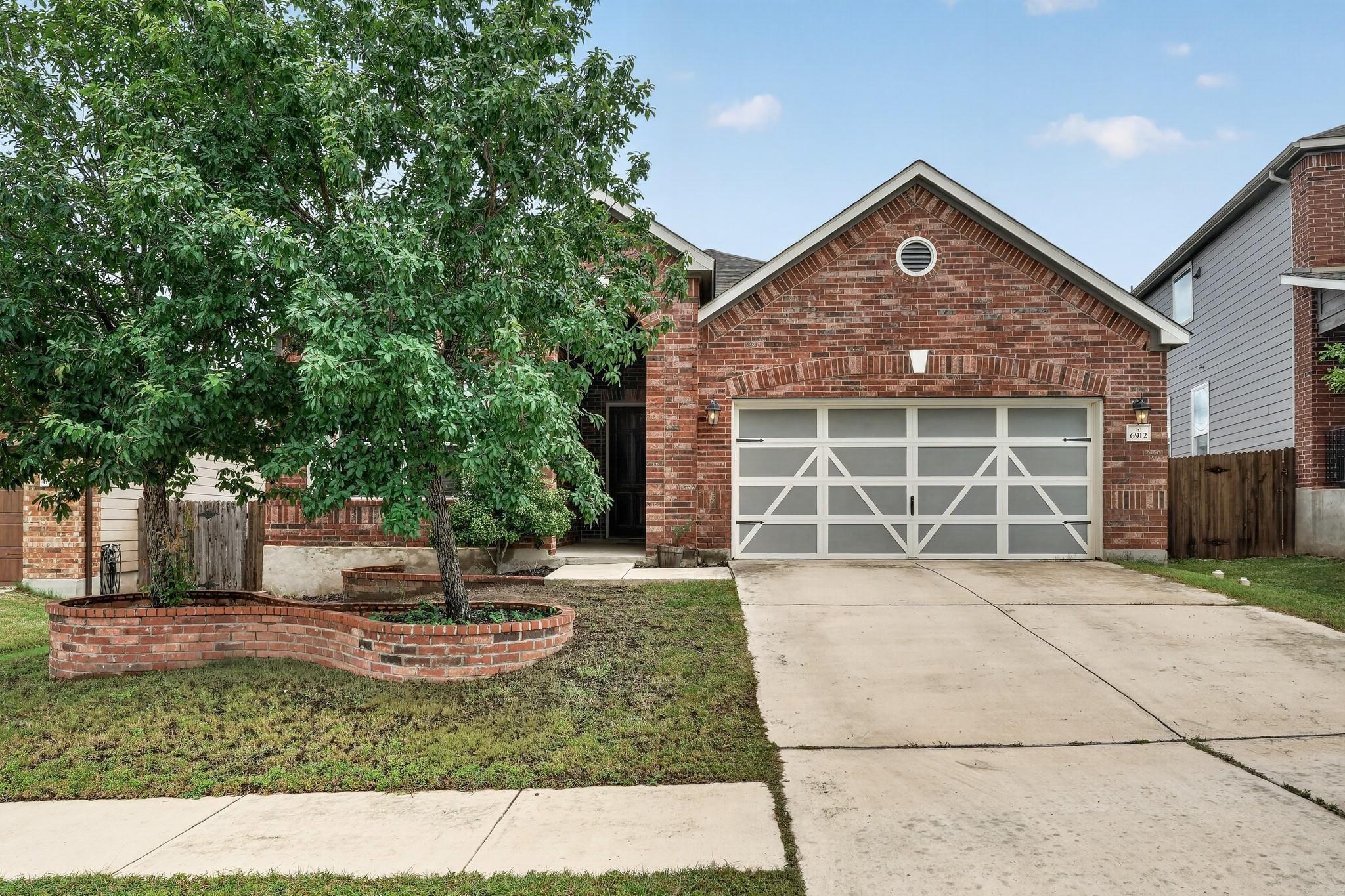 Brick facade welcomes with a patterned garage doo