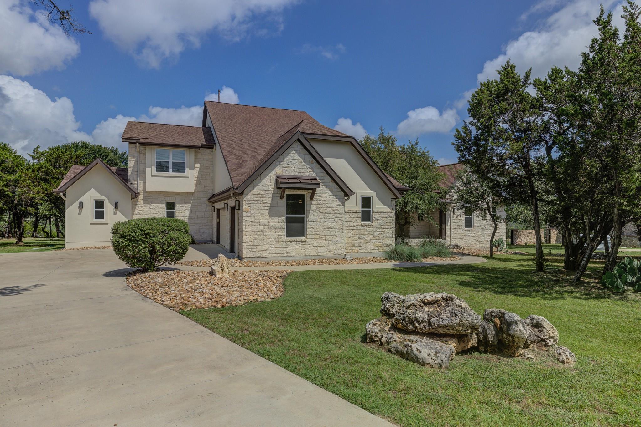 A striking stone and stucco exterior welcomes wit