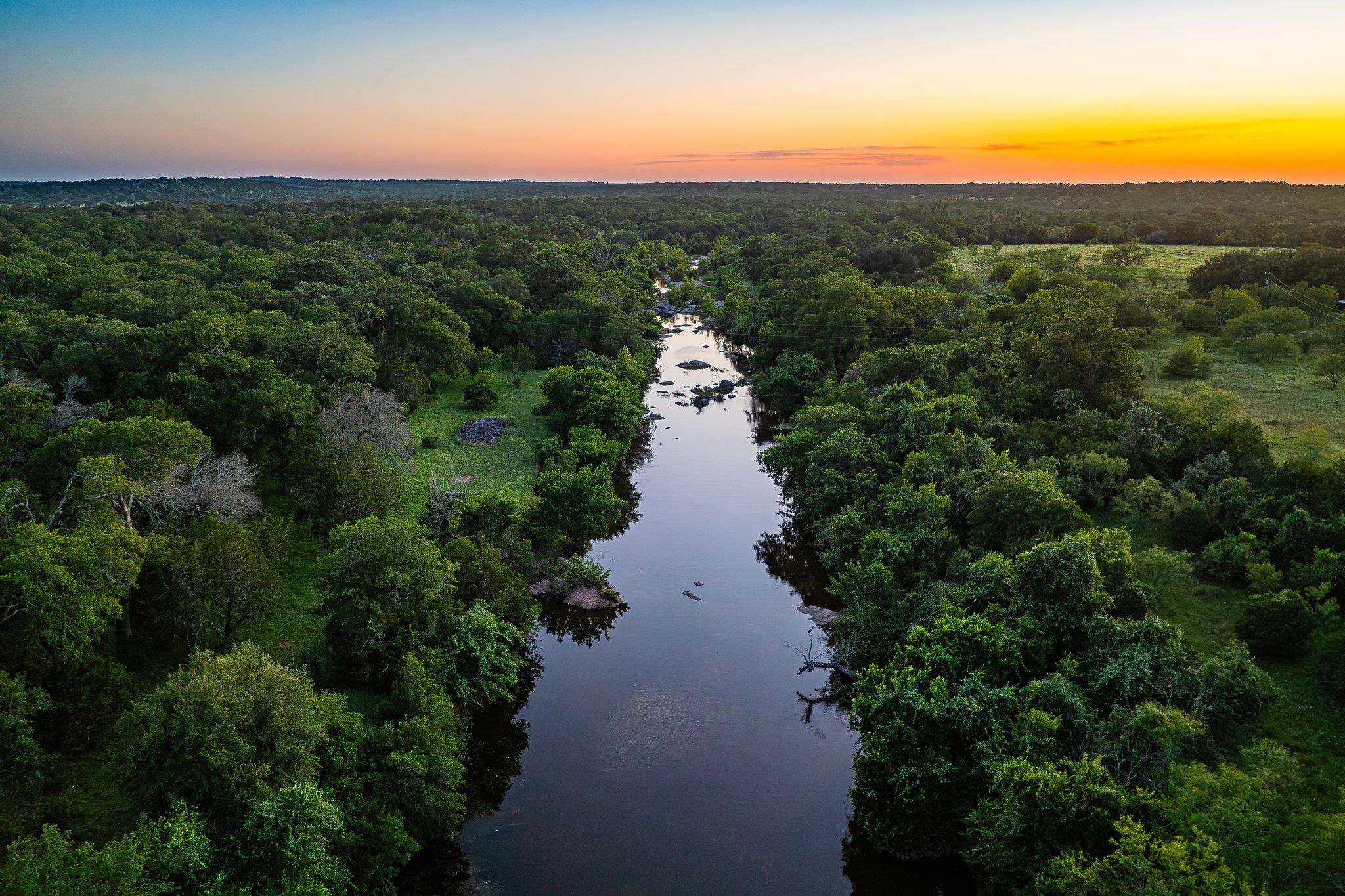 A tranquil river winds through a verdant landscap