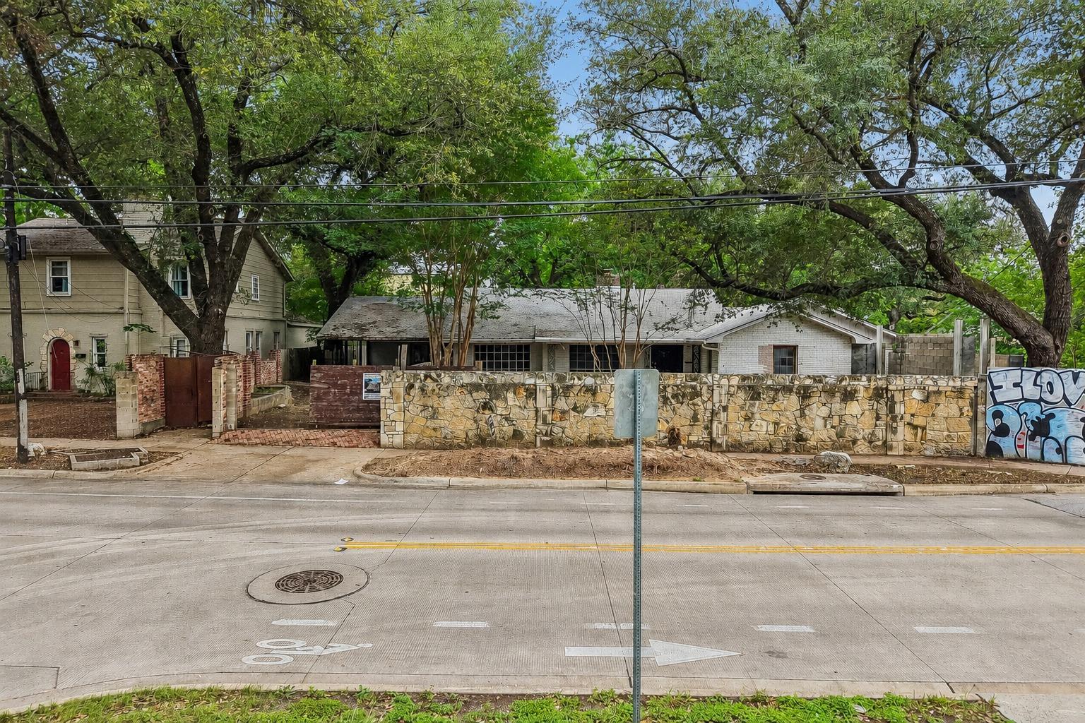 Mature trees canopy this property, featuring a st