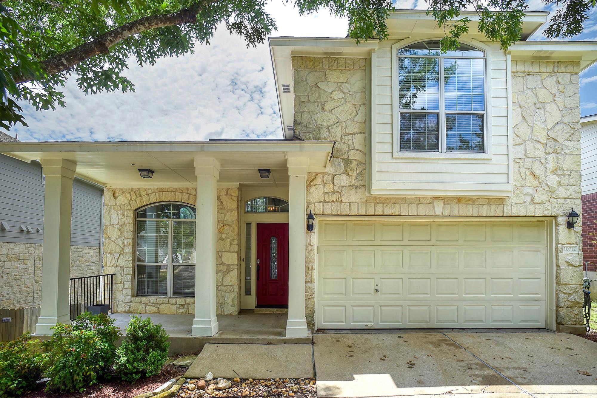 A welcoming stone facade with a bold red entry do