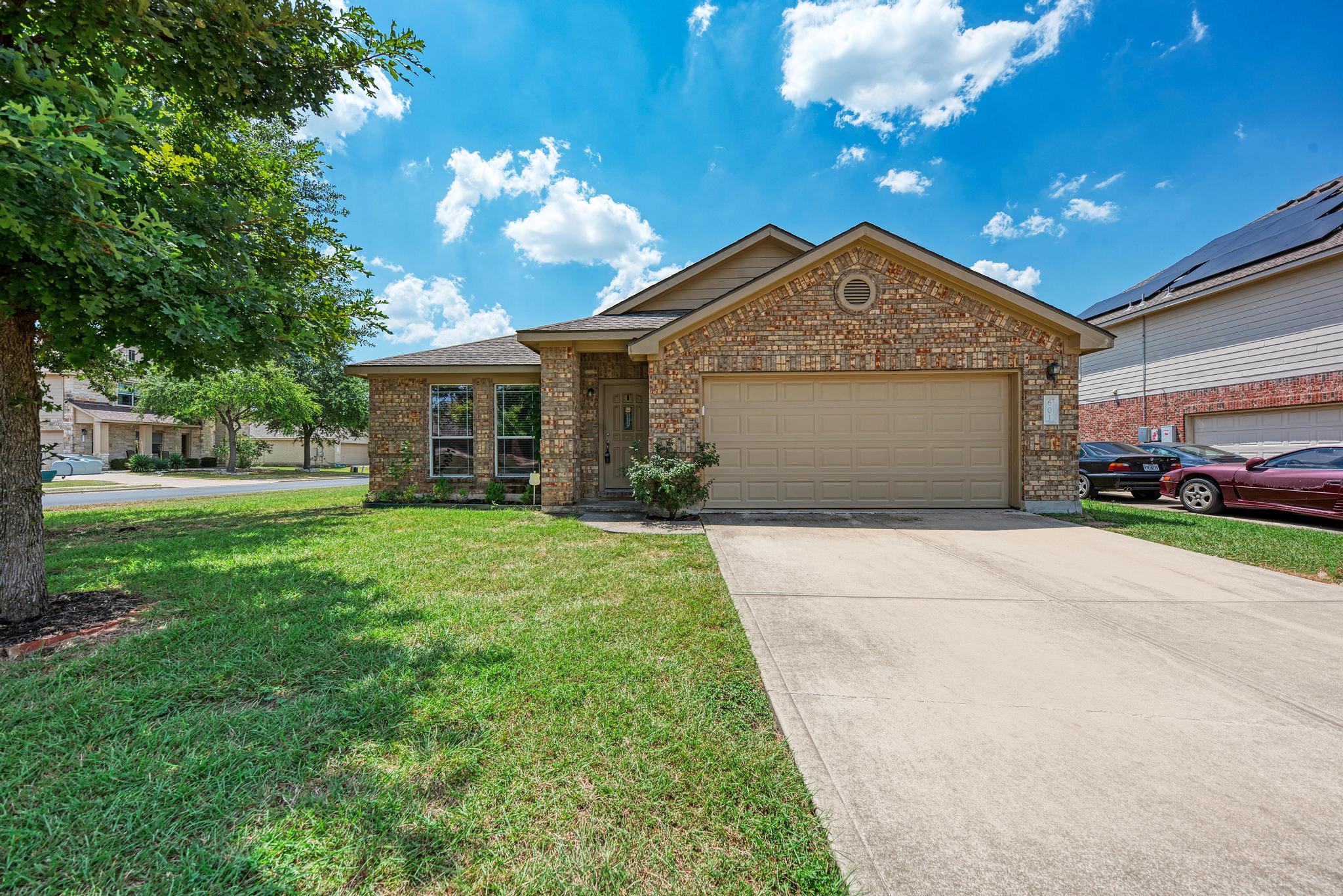 A well-maintained brick facade and driveway creat