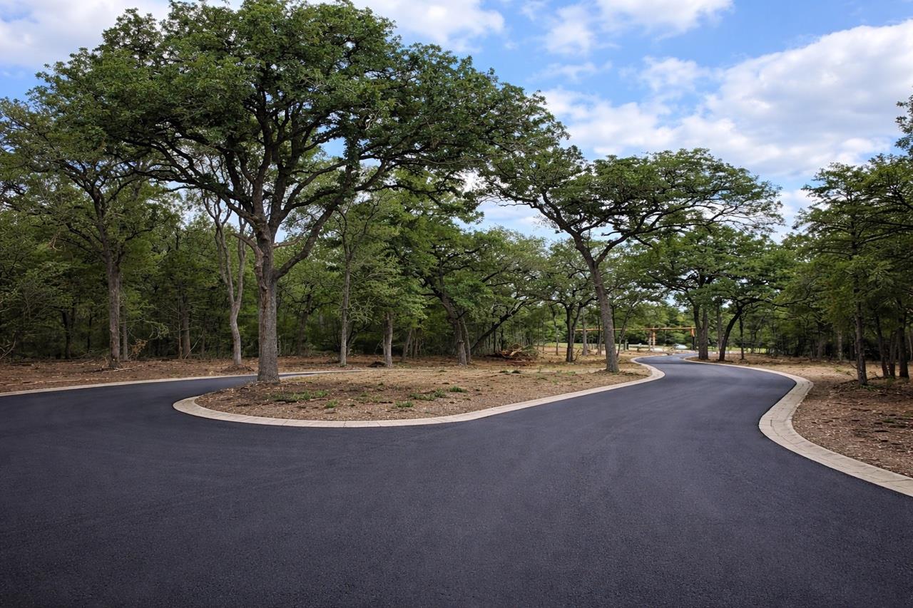 A newly paved winding road meanders through a tra
