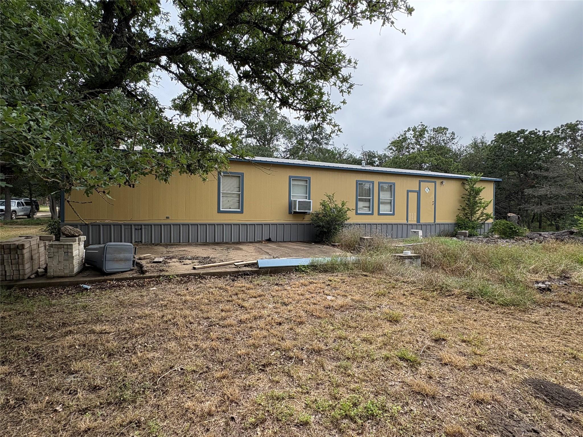 A manufactured home with mature trees and ample o
