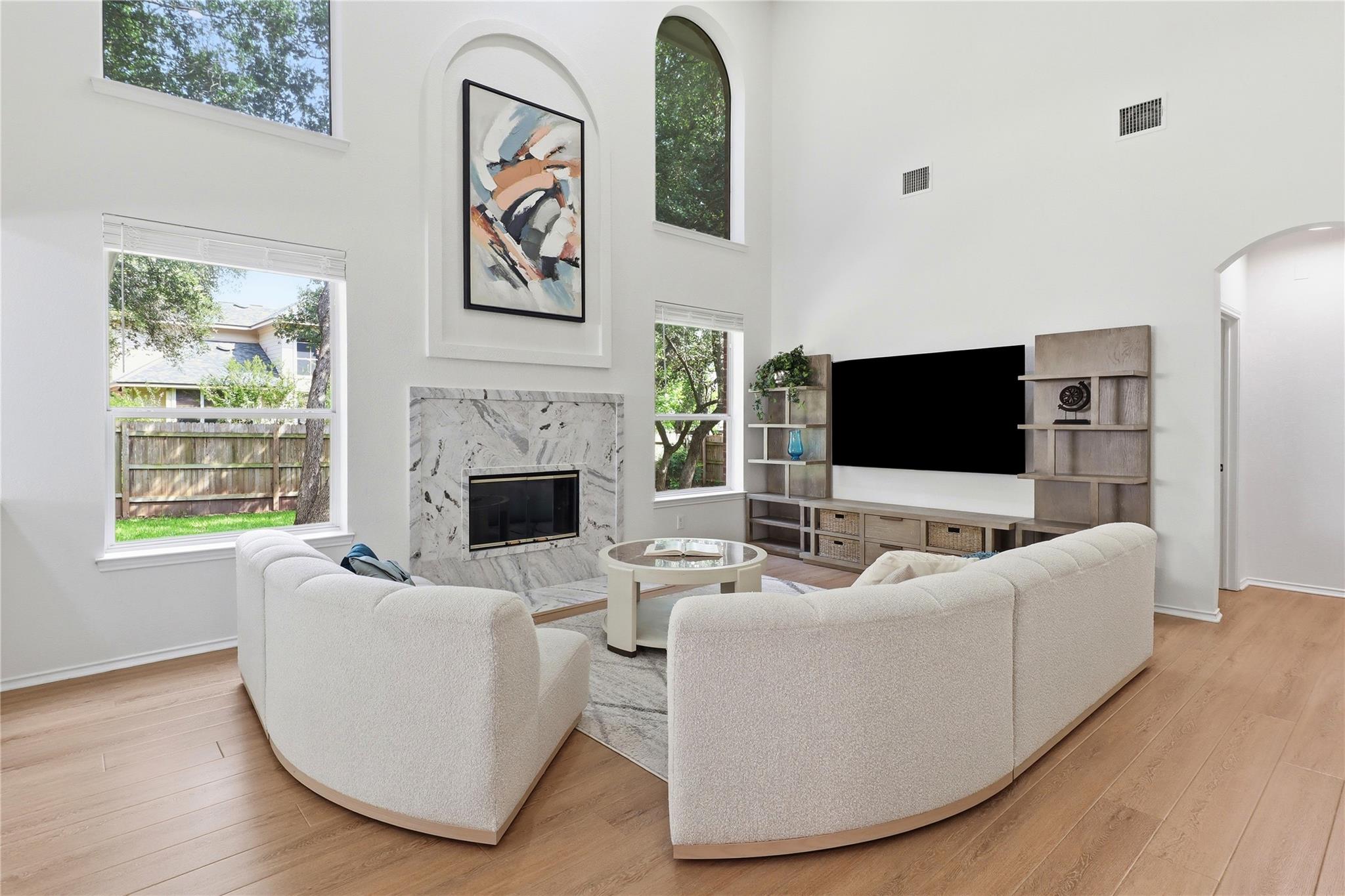 A well-lit living area features a grand fireplace