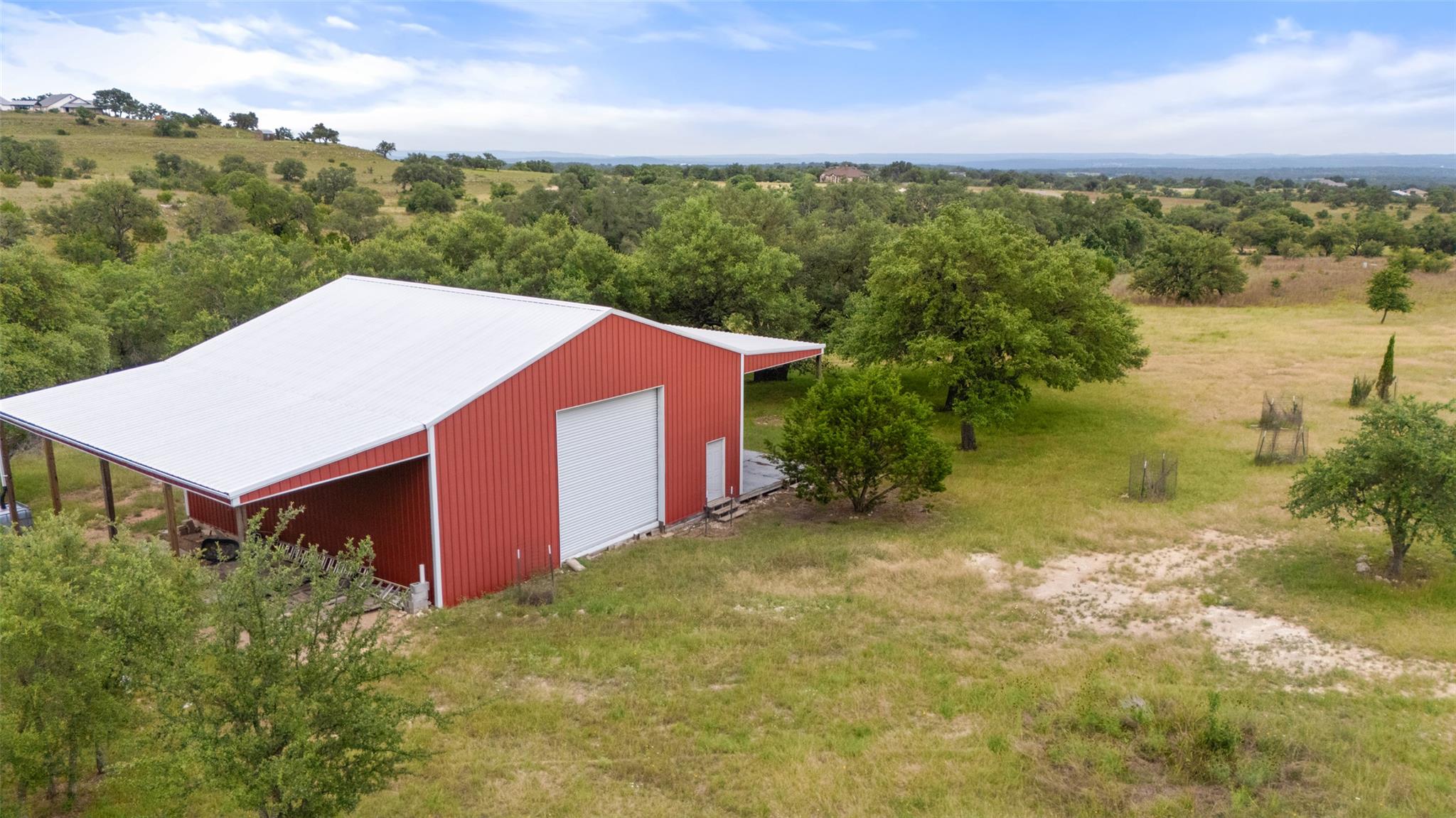 A vibrant red barn with a white metal roof stands