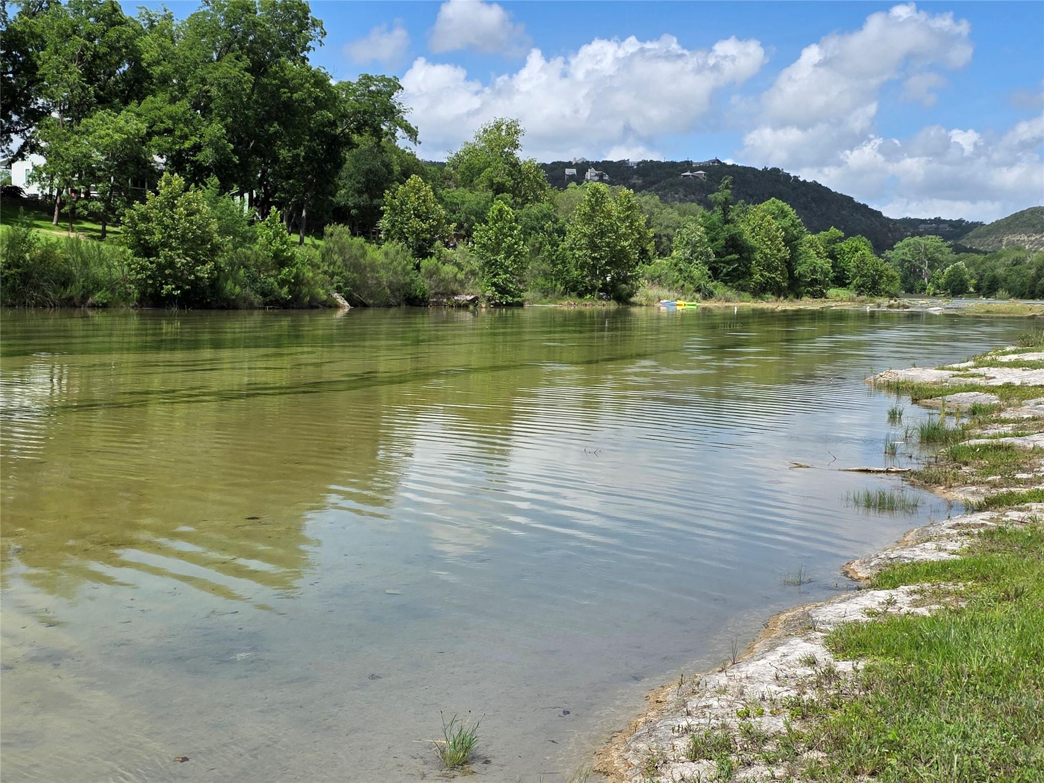 A tranquil riverfront property with lush trees an
