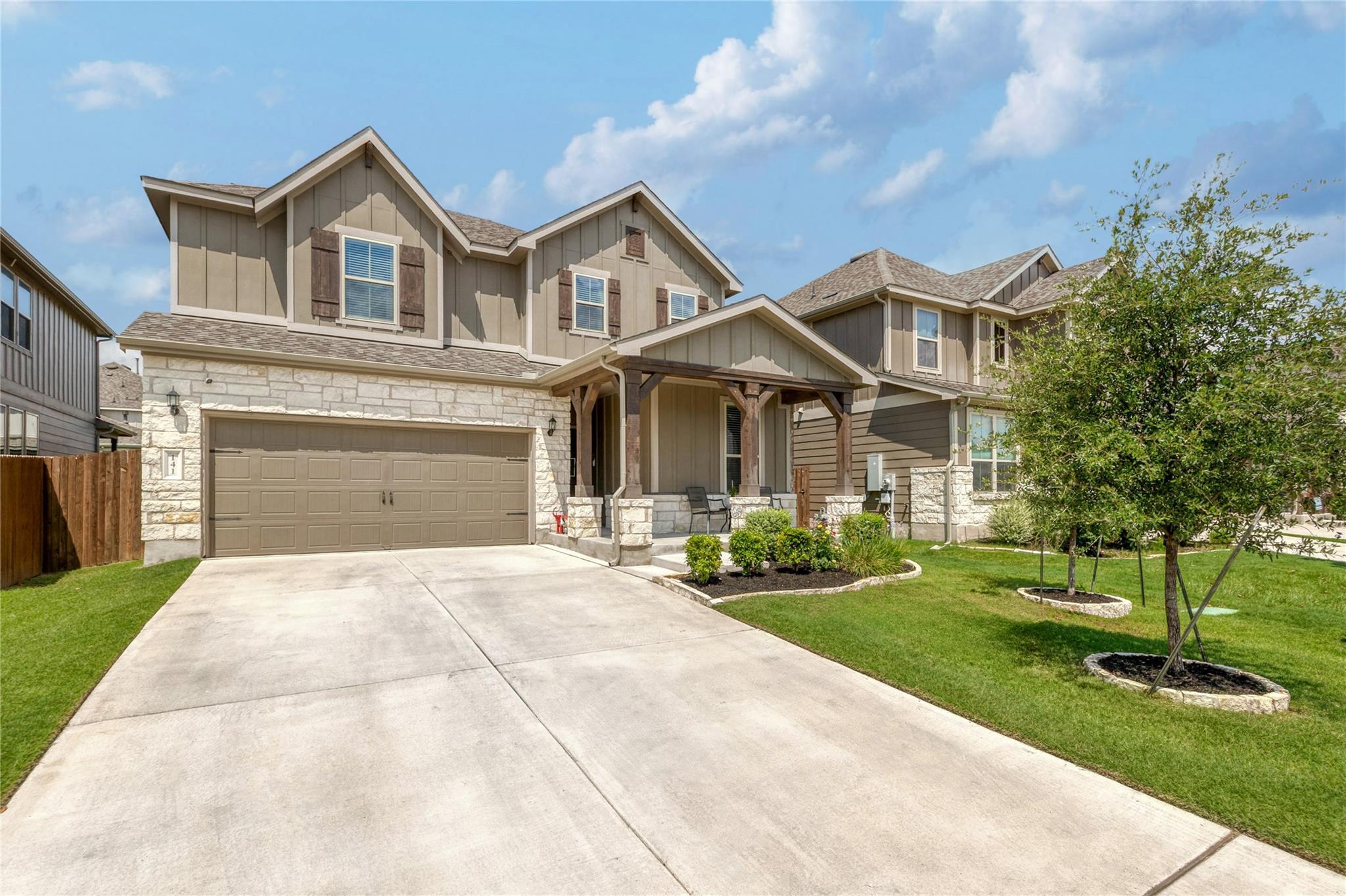 A welcoming stone and siding facade with a covere