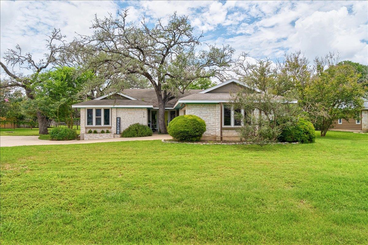A sprawling green lawn complements this inviting 