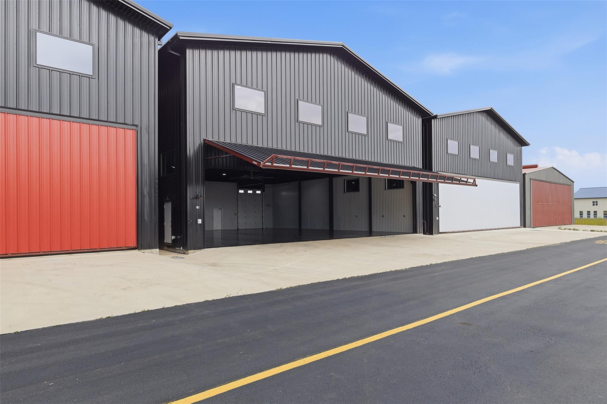 Aircraft hangar with expansive entry for convenie