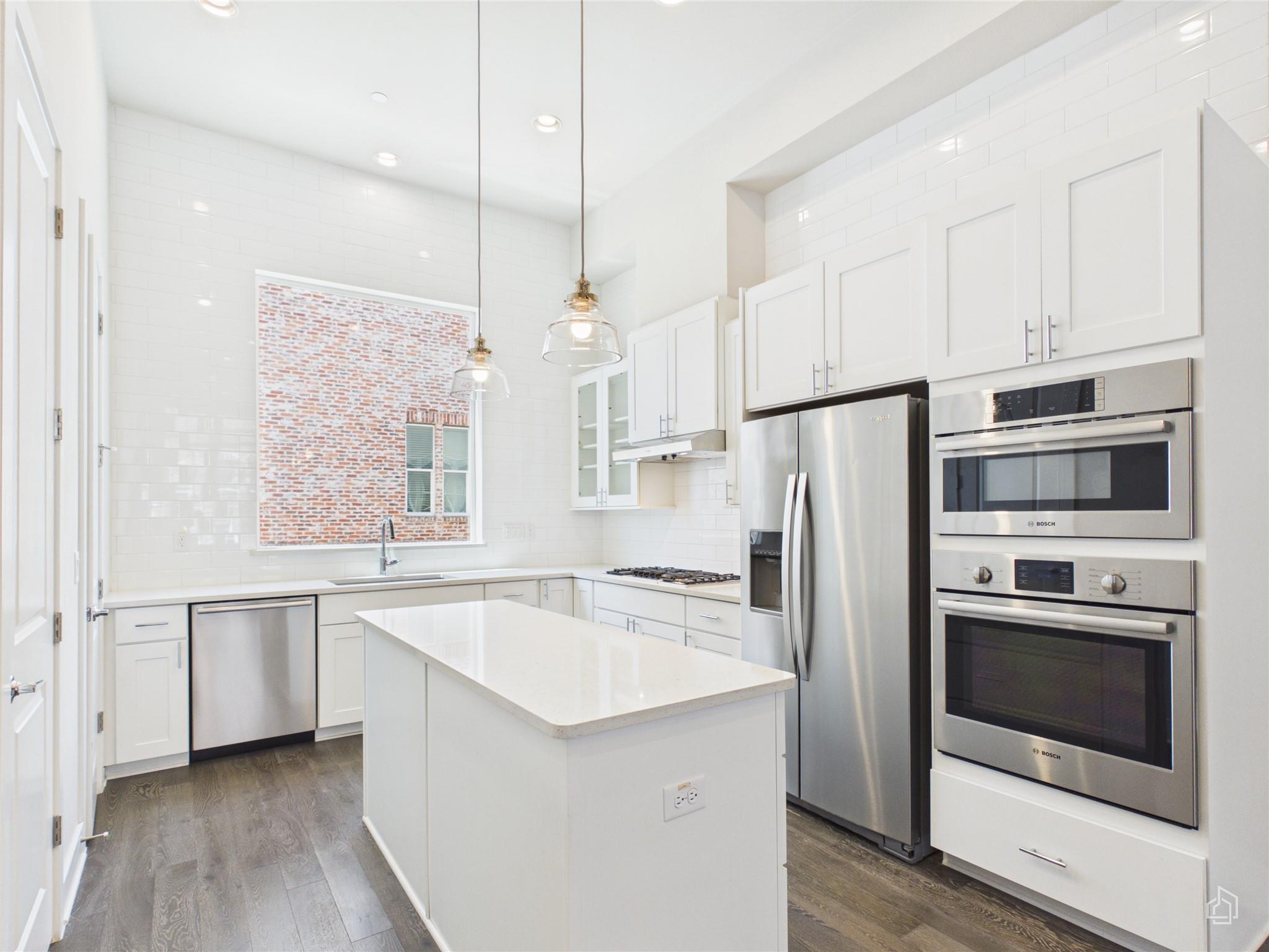 High ceilings and sleek stone countertops define 