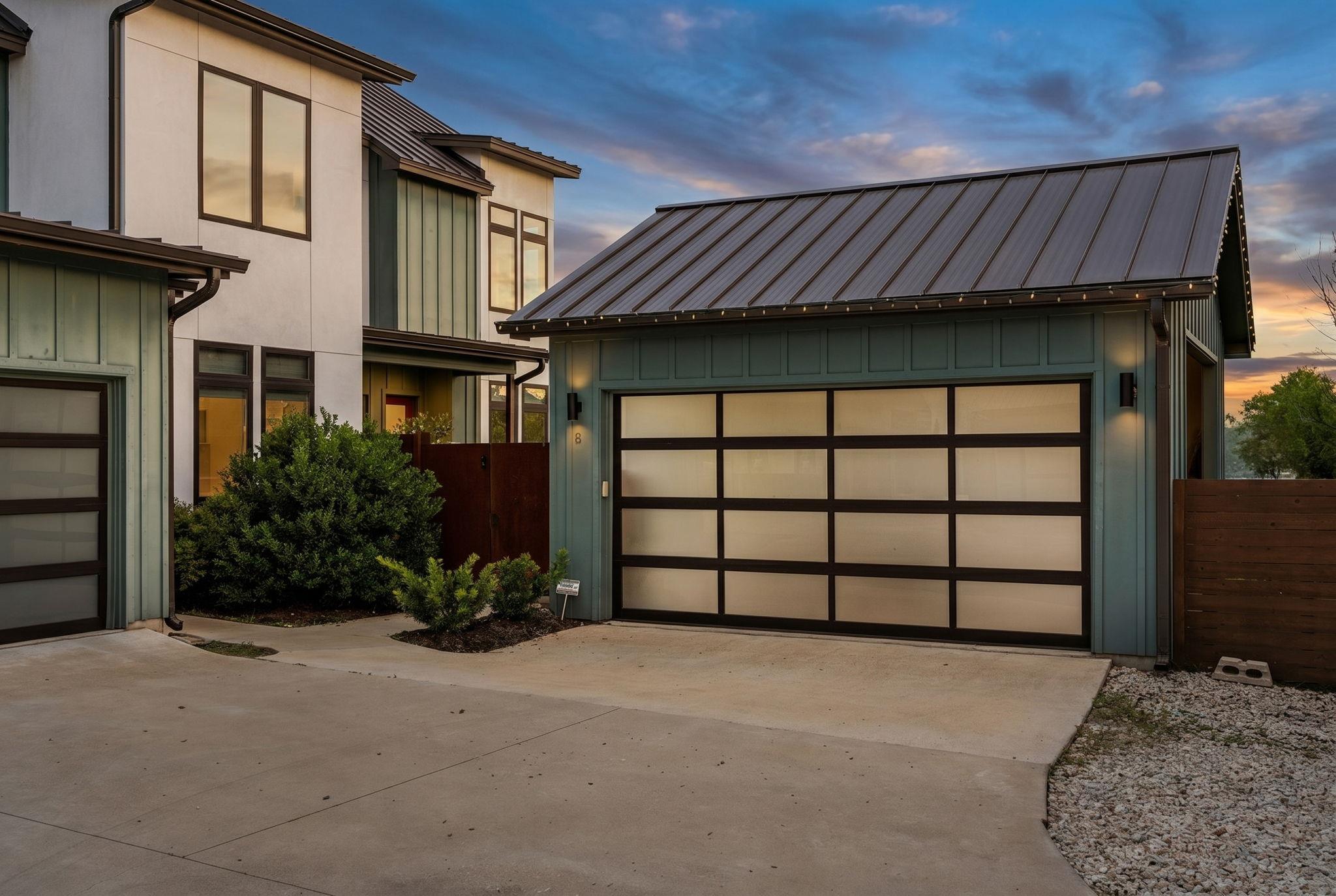 A striking modern exterior features a two-car gar