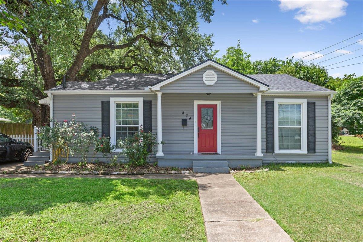 A charming cottage facade featuring a bright red 