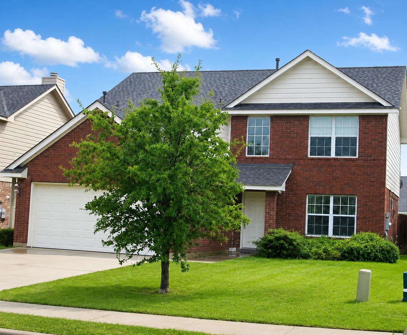 Brick facade with an integrated garage offers cla