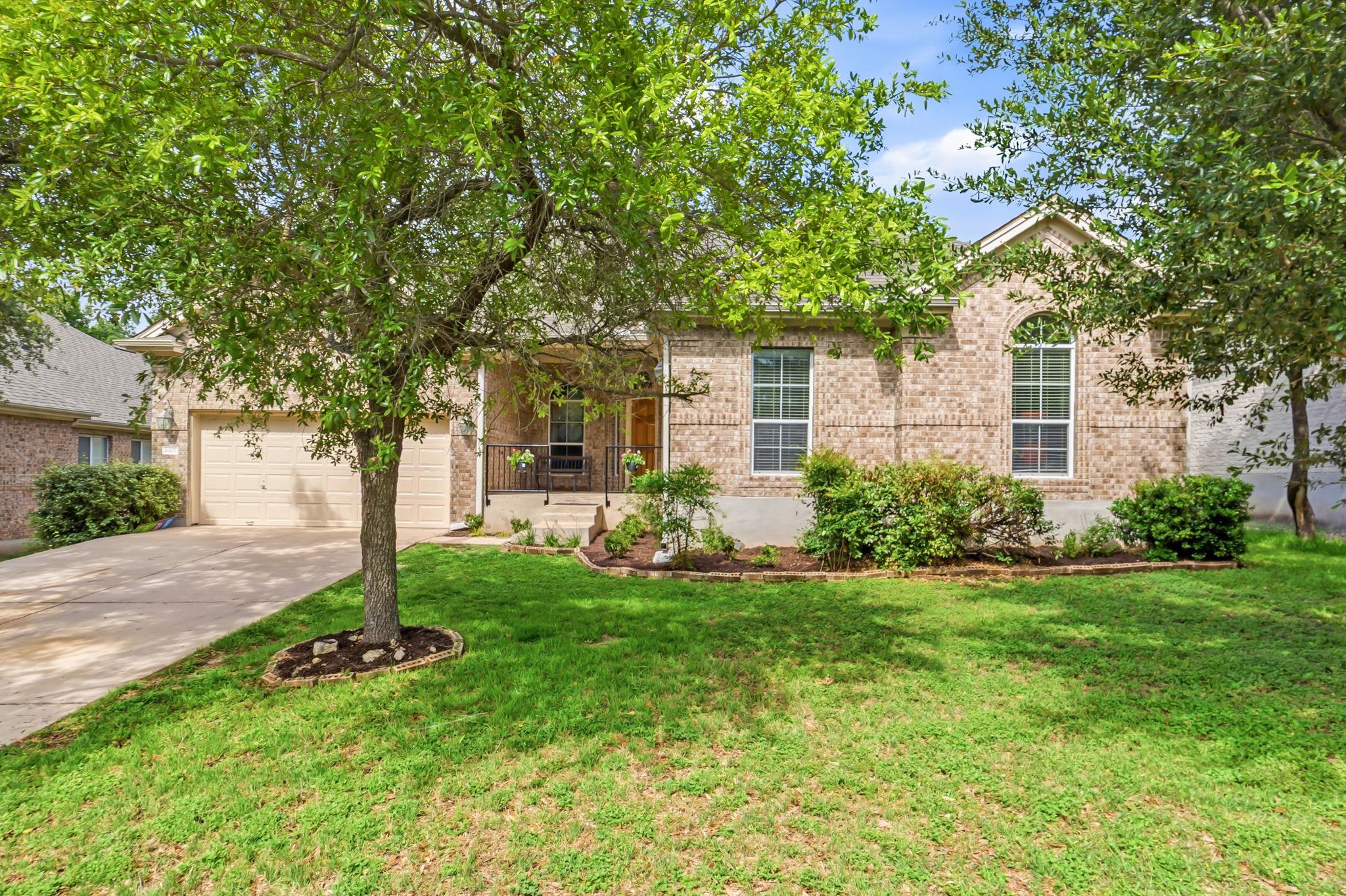 A classic brick exterior, inviting porch, and wel