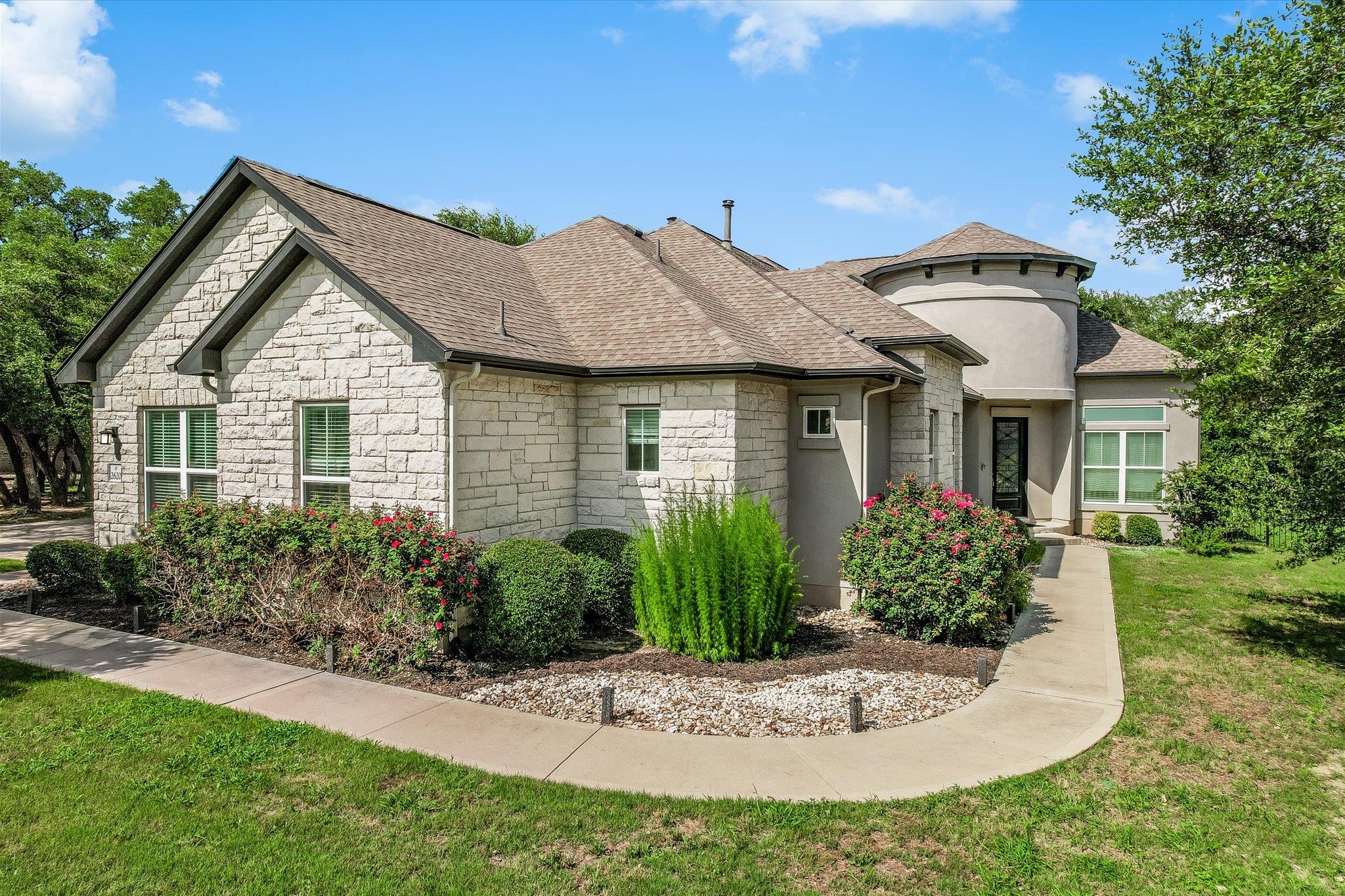 An inviting stone and stucco exterior welcomes wi