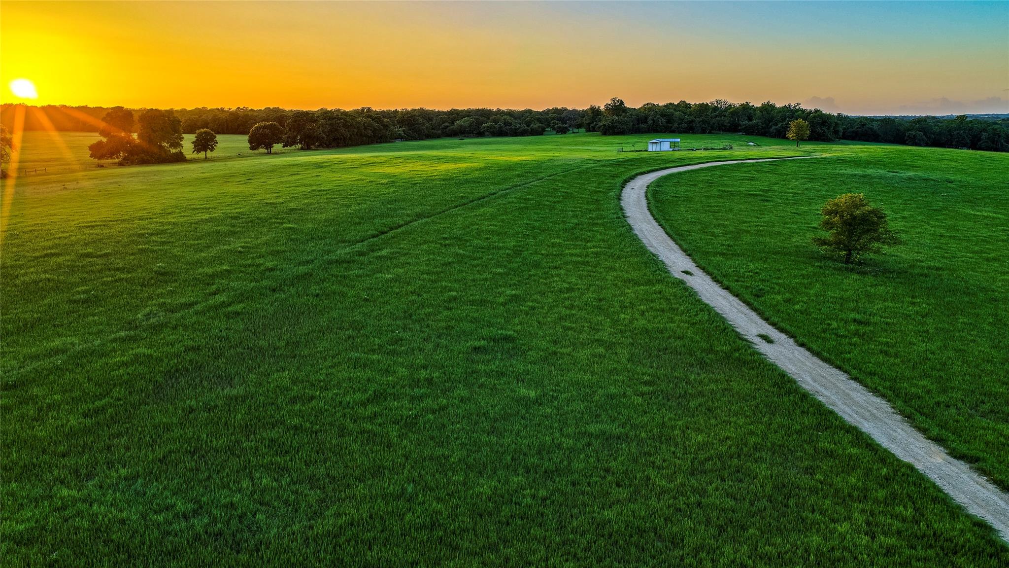 Rolling green hills and a meandering path lead to