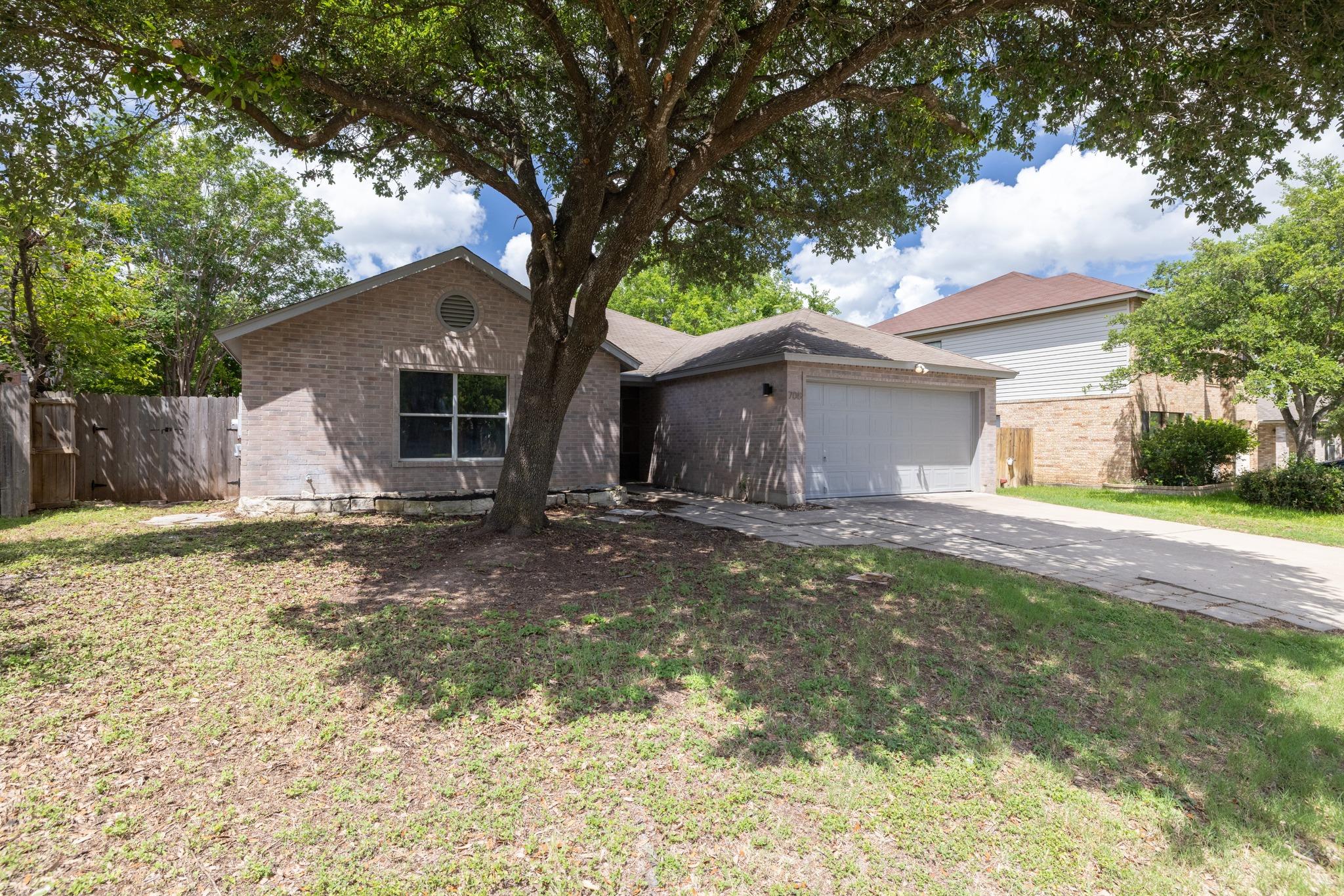 Mature trees shade this charming brick home with 