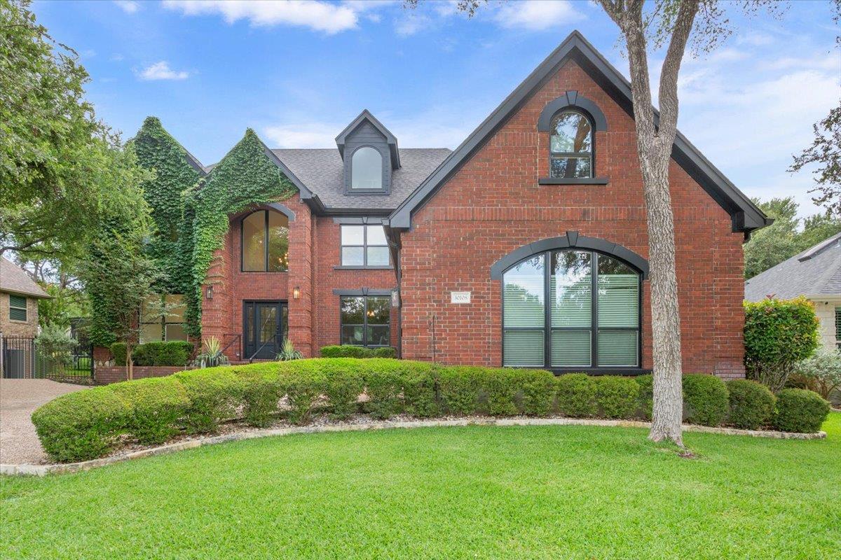 A brick-clad residence with arched windows and ve